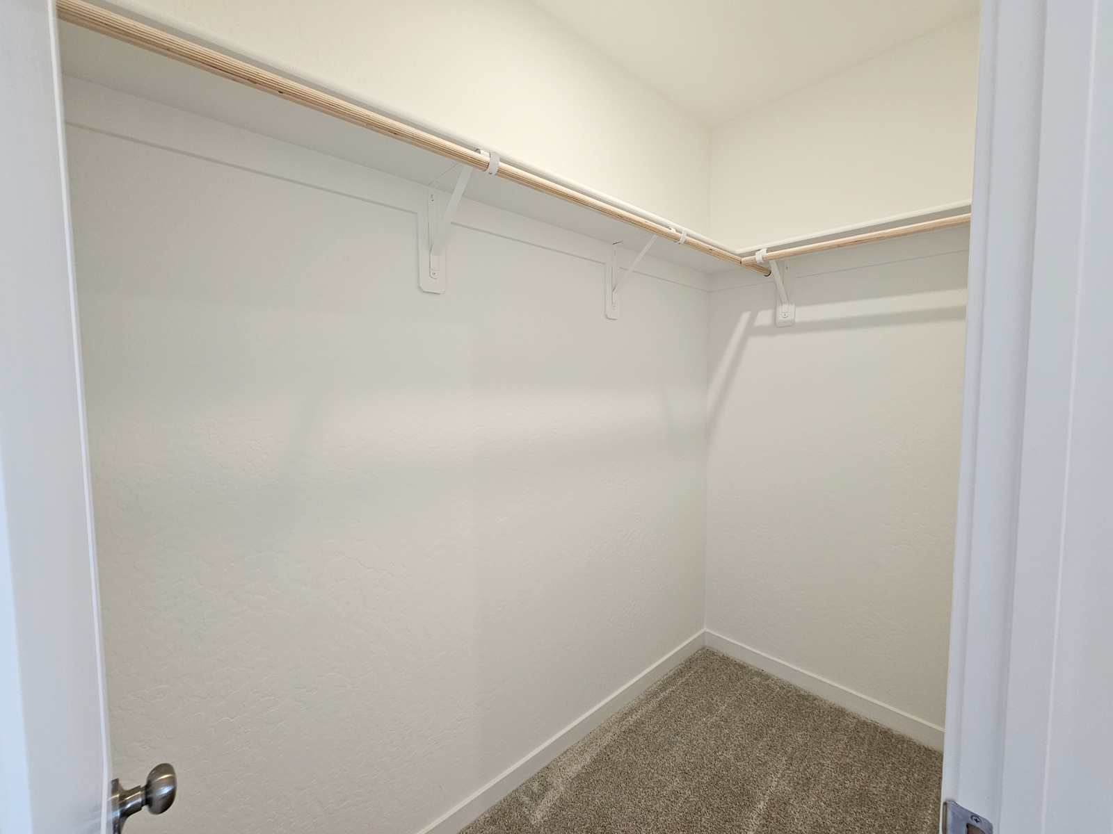 A white door with a metal bar.