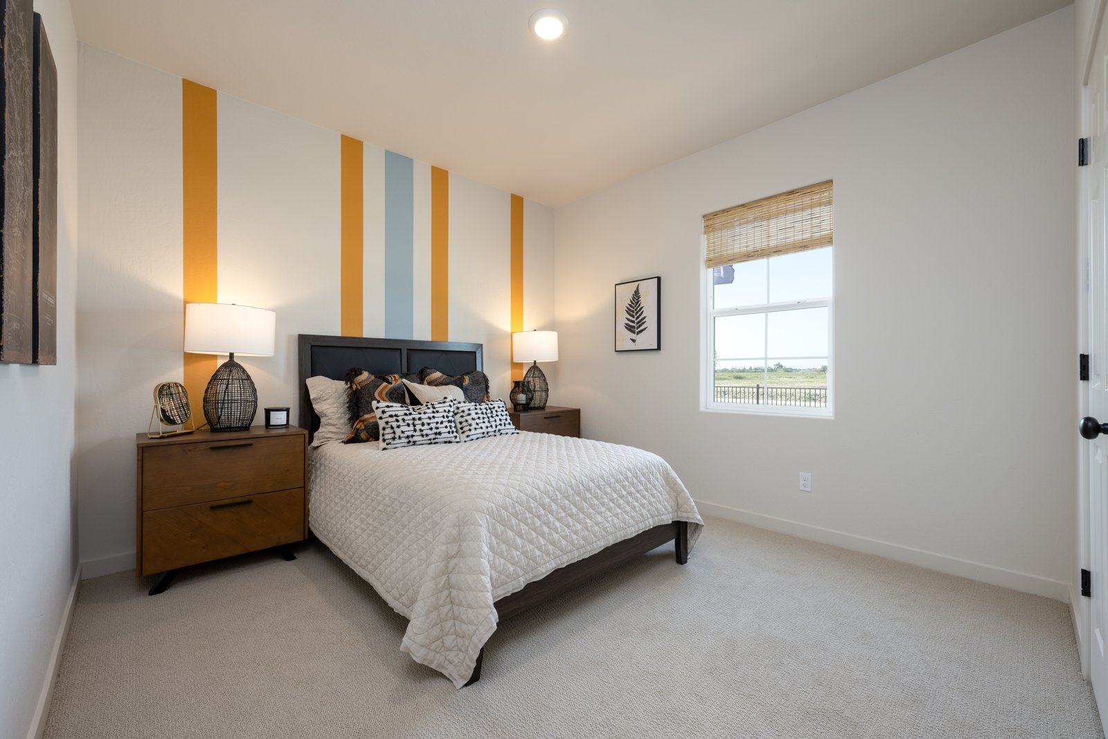 A bedroom with a bed and lamps.