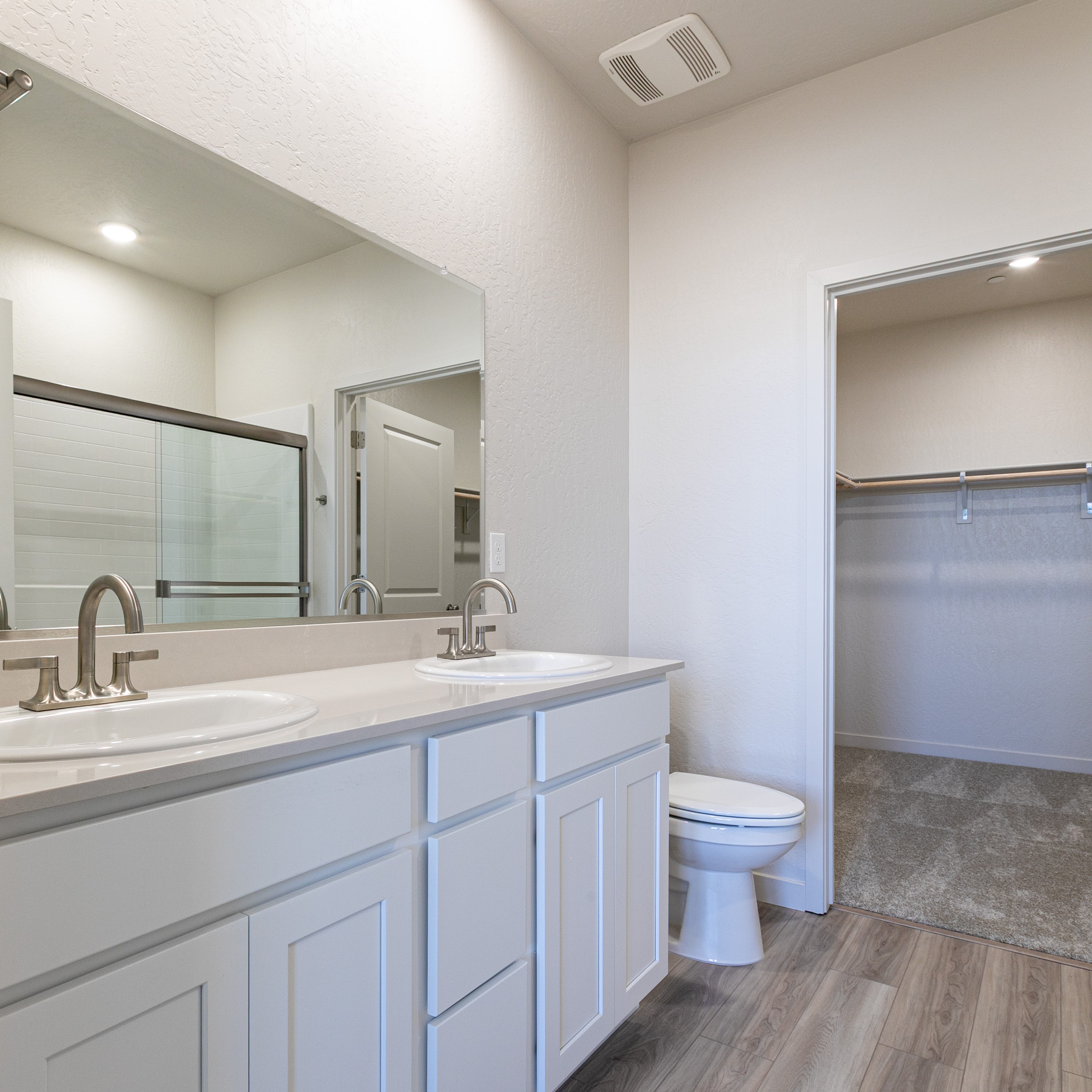 A bathroom with a toilet sink and mirror.