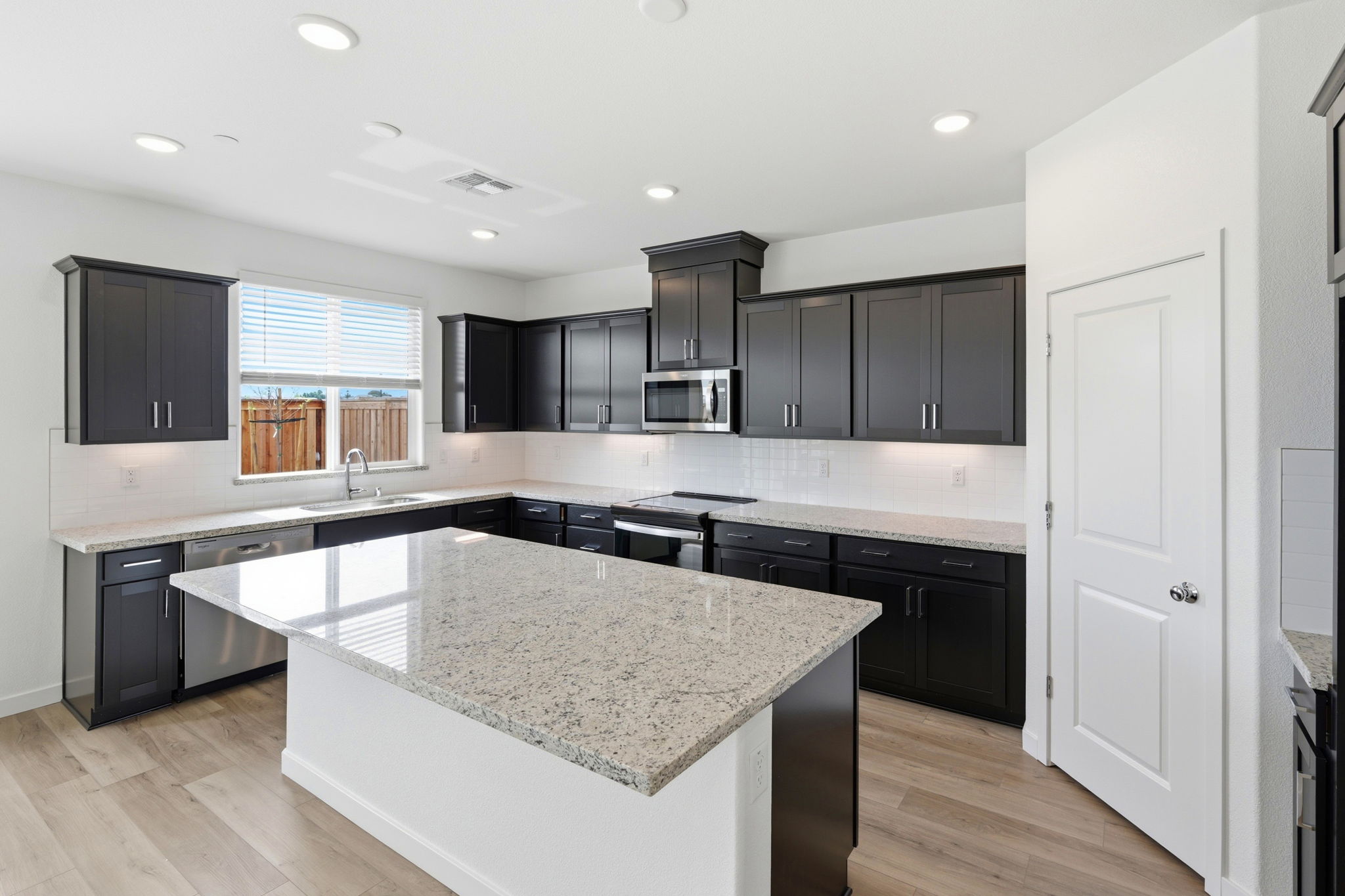 A kitchen with black cabinets.