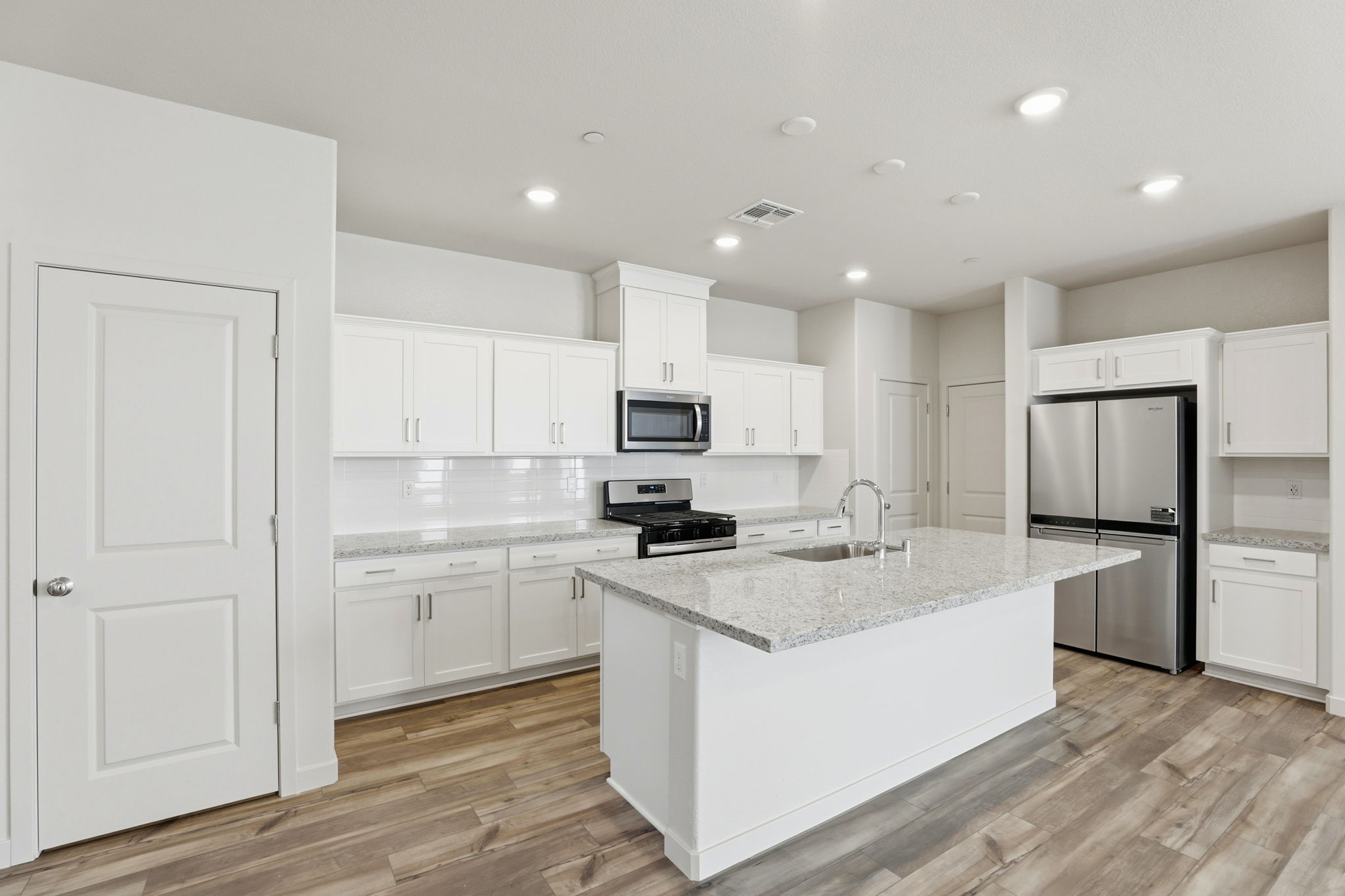 A kitchen with white cabinets.