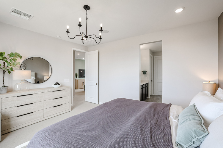 A bedroom with a bed and a mirror.