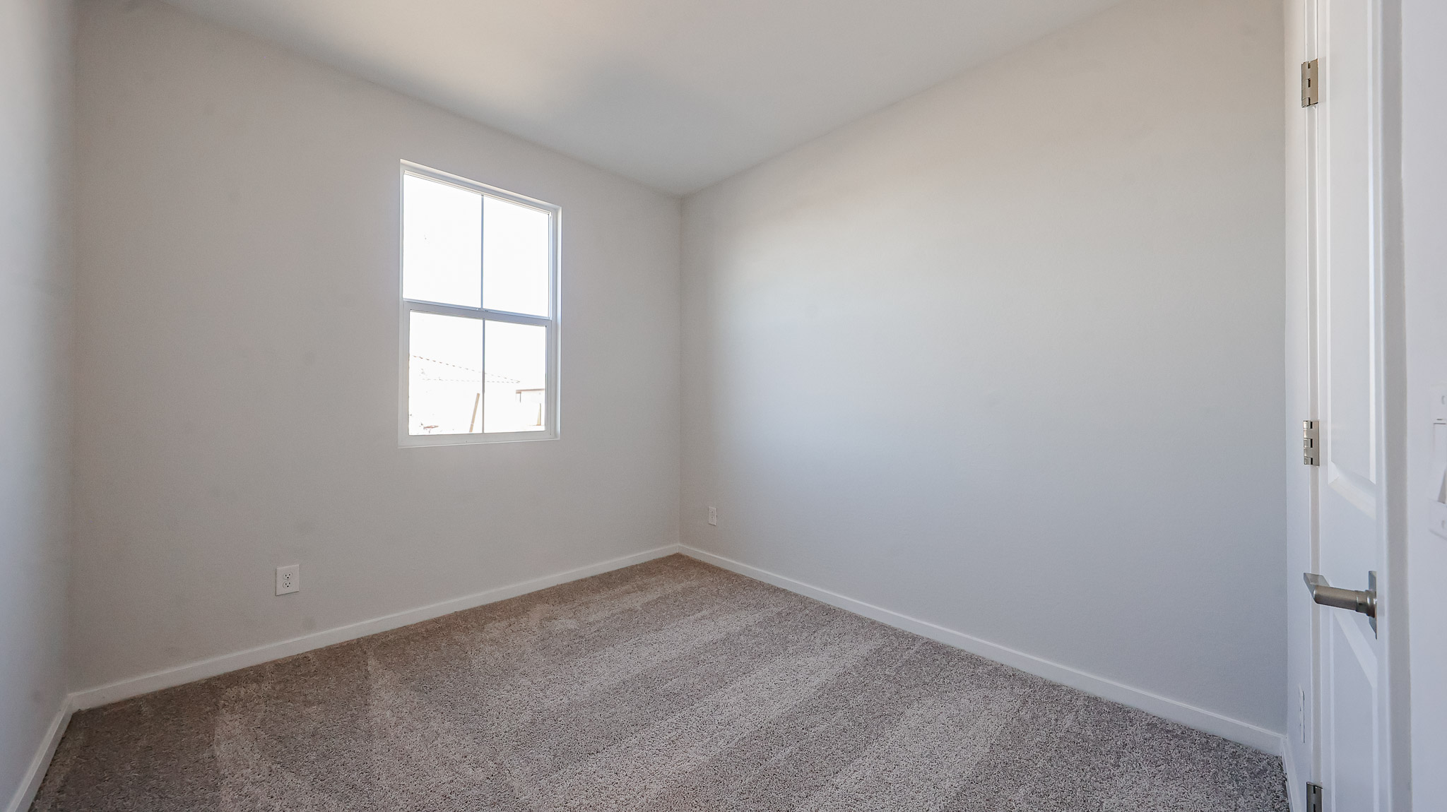 A room with a carpet and a window.