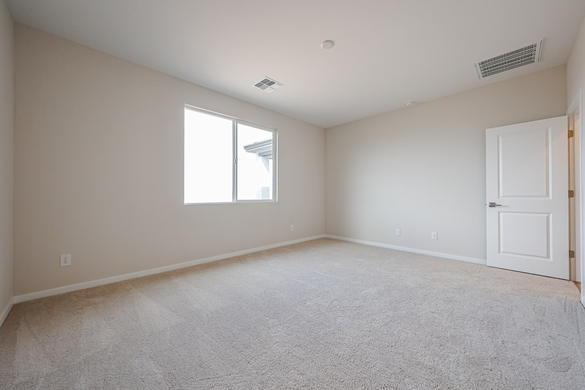 A room with a carpet and a window.