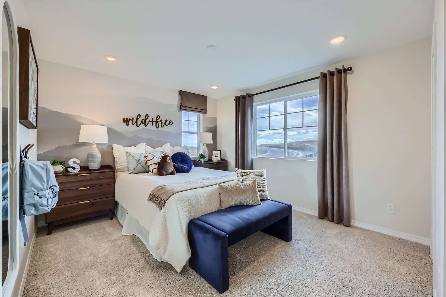 A bedroom with a bench and a window.