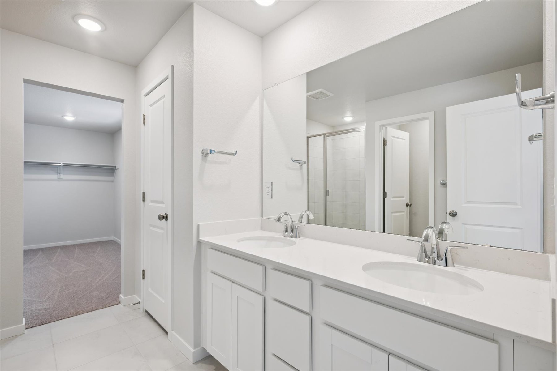 A bathroom with white cabinets.