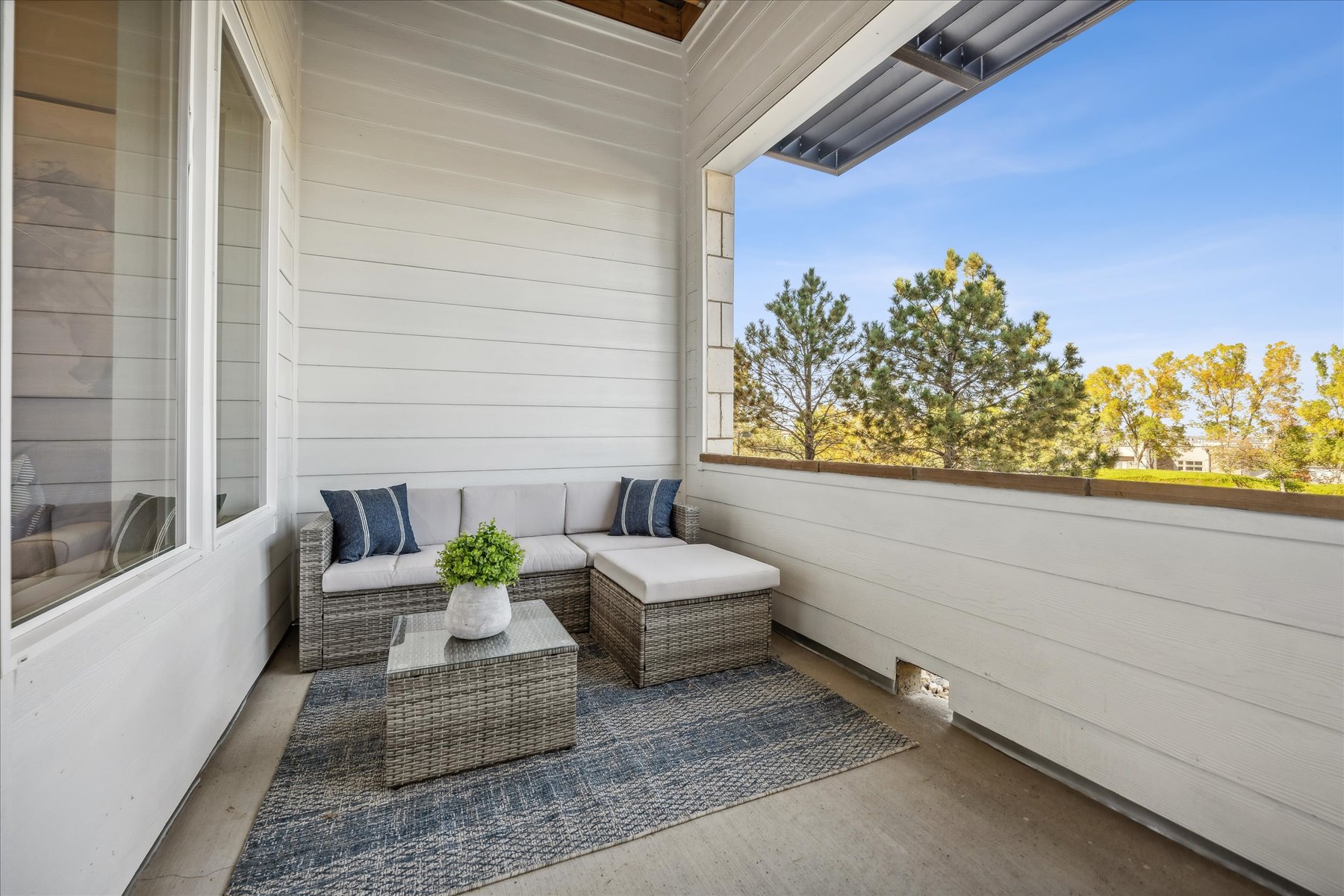 A white house with a patio and a couch and a table.