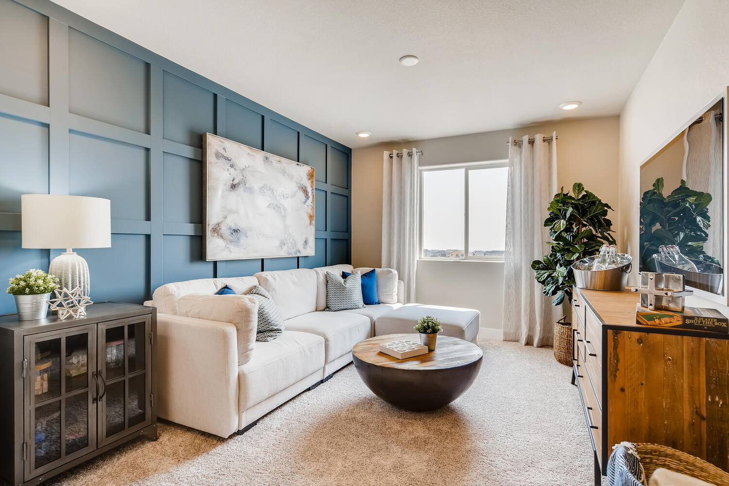 A living room with a white couch and a round table.