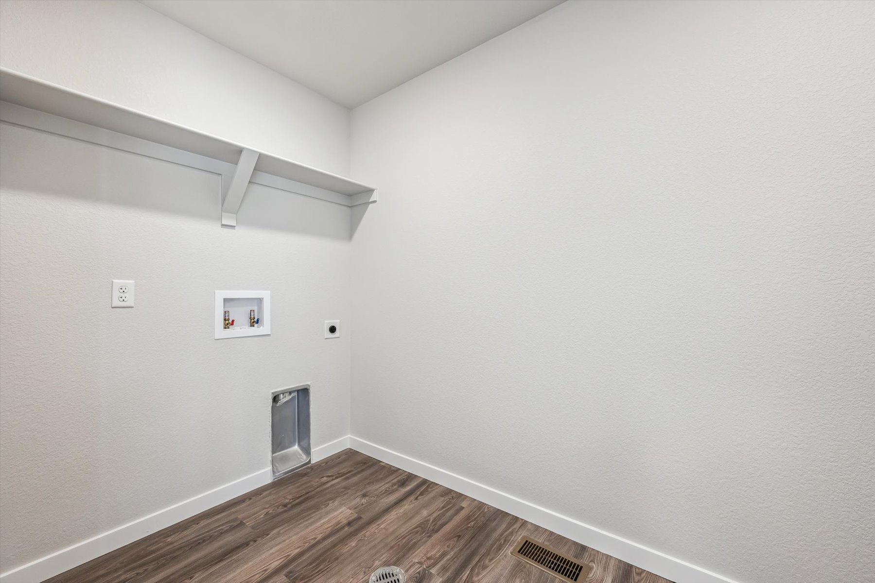 A white room with a wood floor and a wood floor.