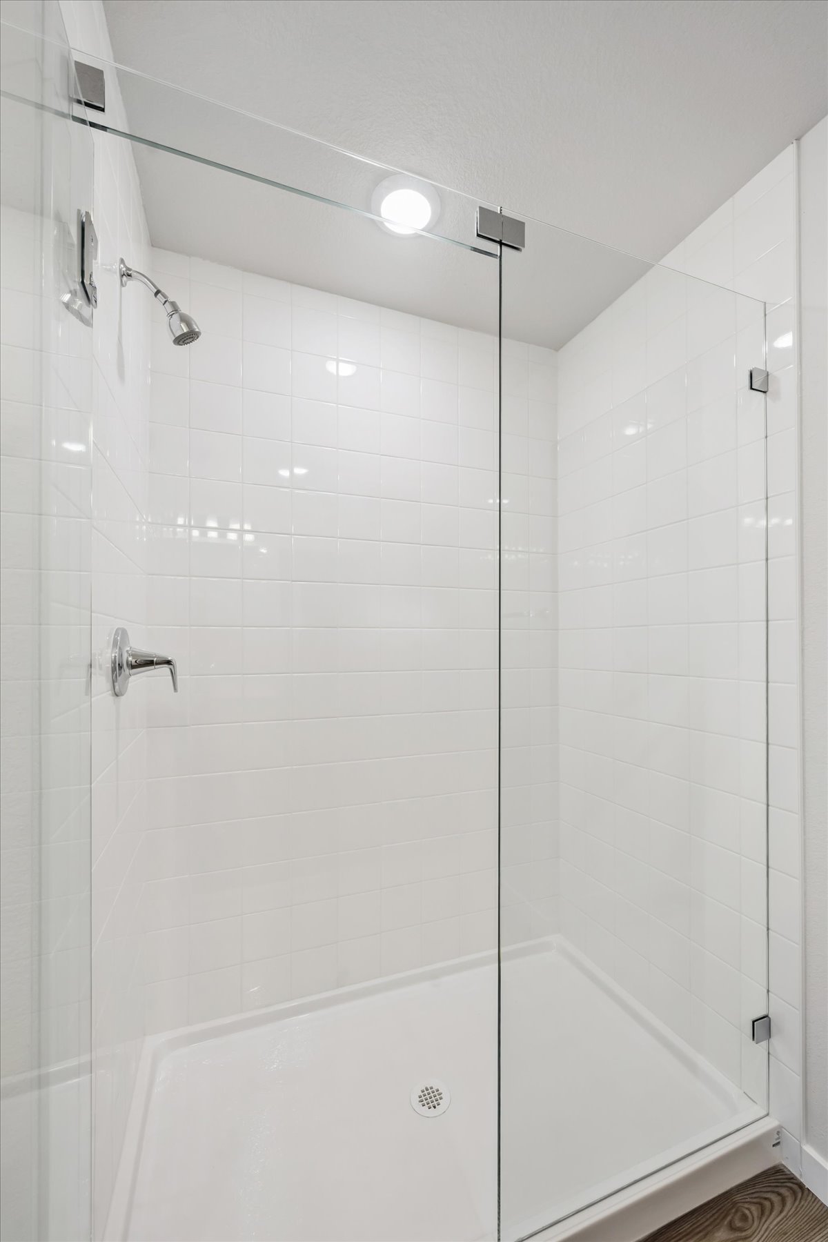 A white shower with a glass door.