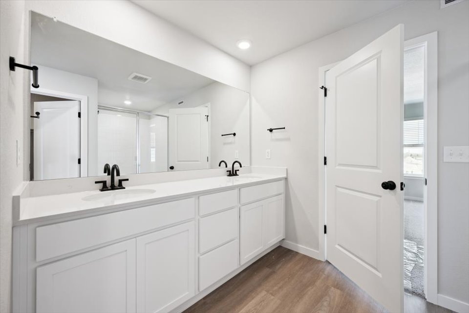 A bathroom with white cabinets.