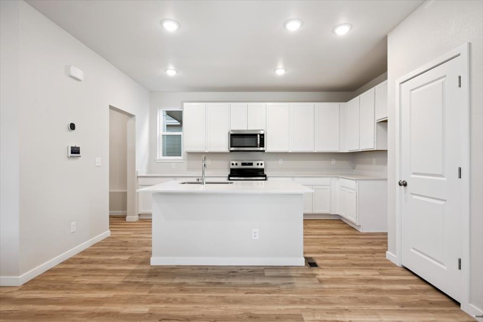 A kitchen with white cabinets.