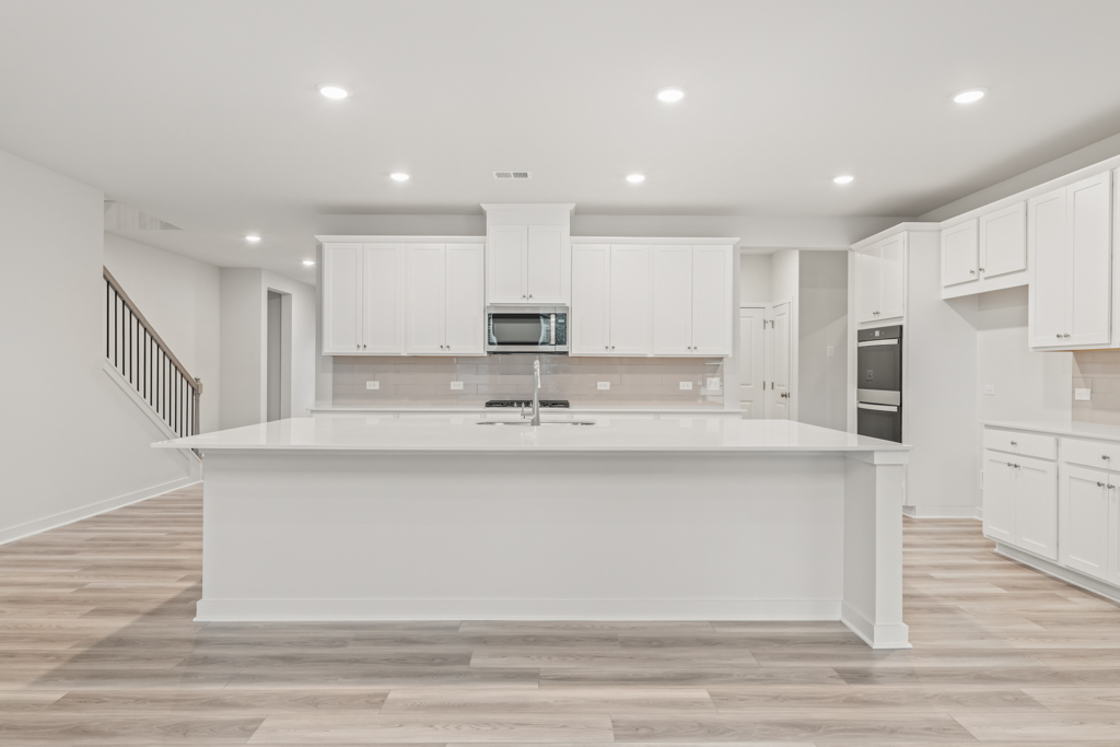 A kitchen with white cabinets.