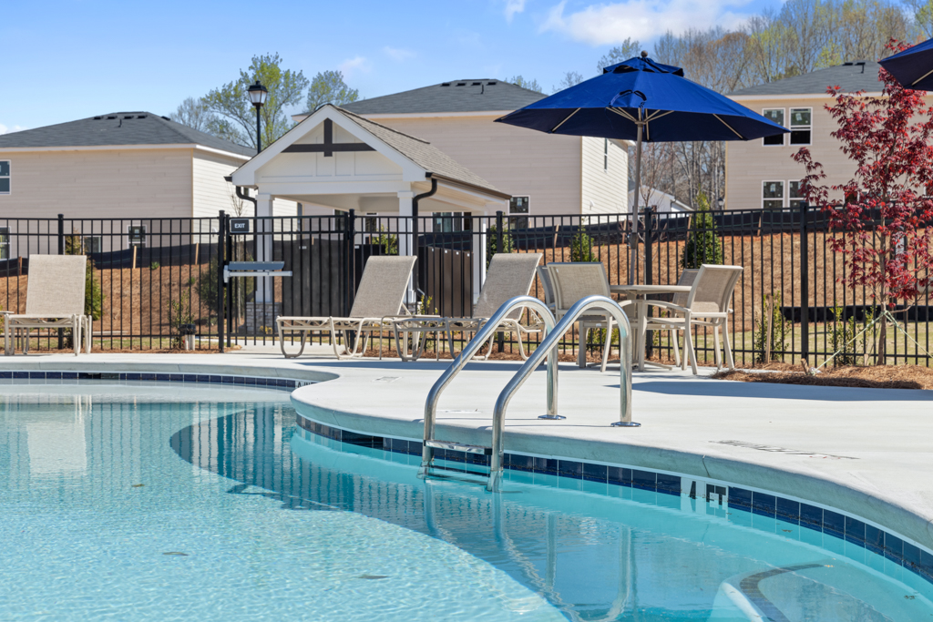 A pool with a table and chairs by it.