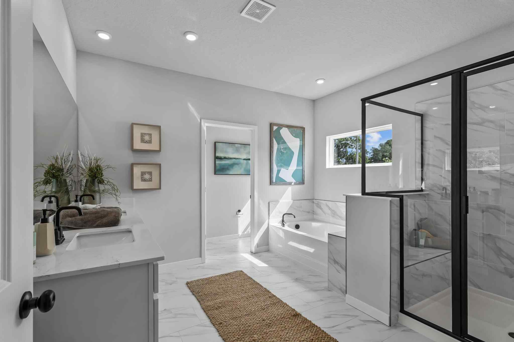 A bathroom with a tub sink and a shower.