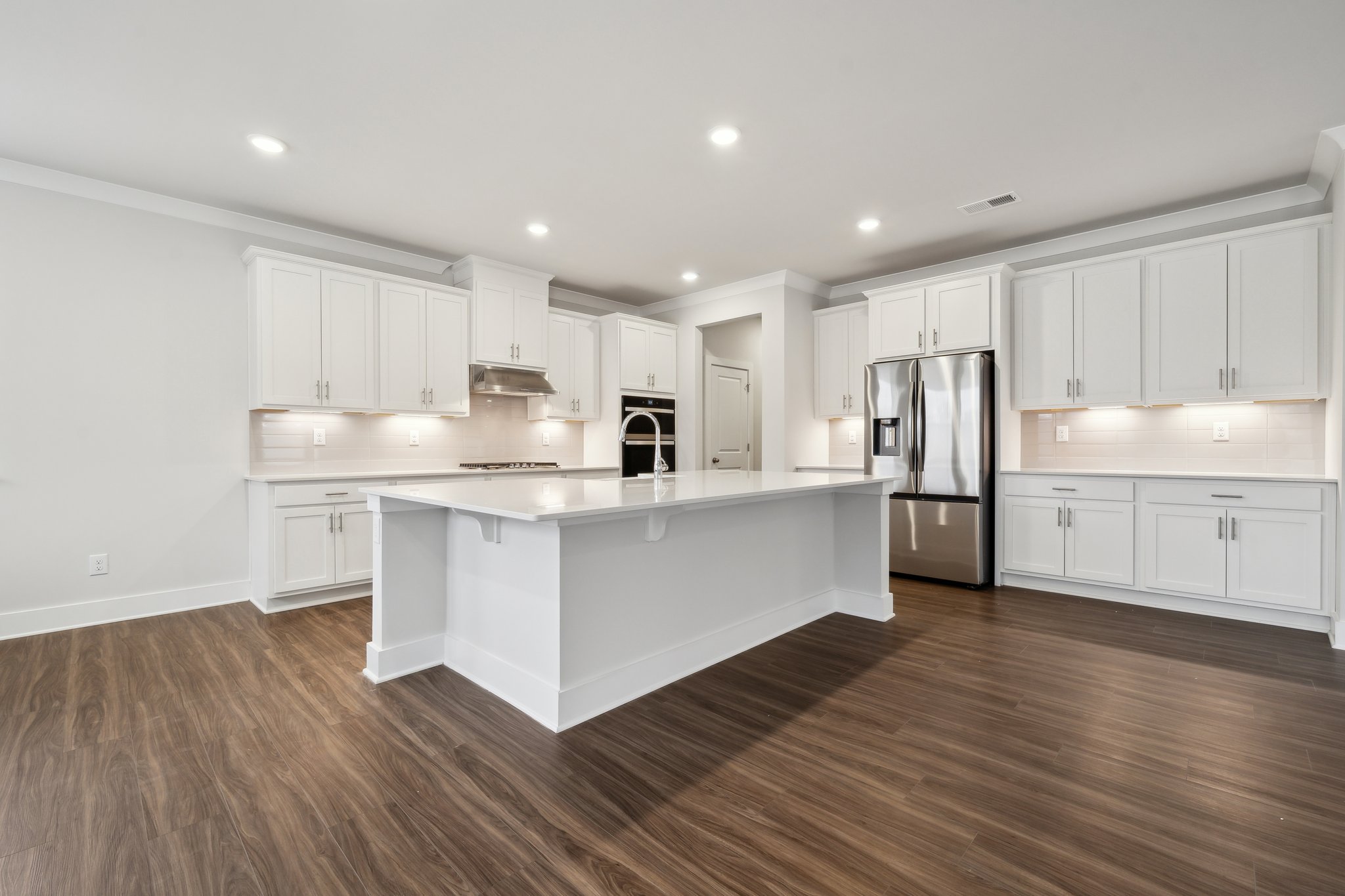 A kitchen with white cabinets.
