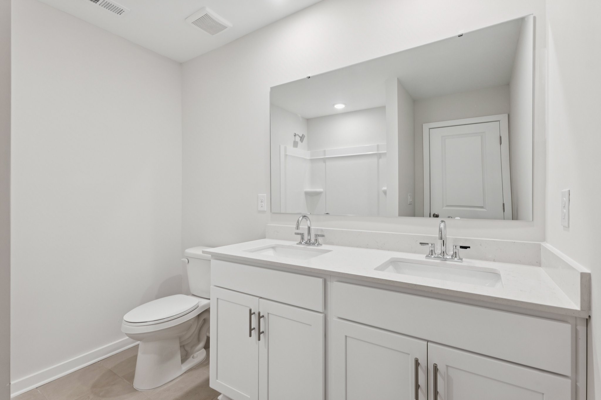A bathroom with a large mirror.