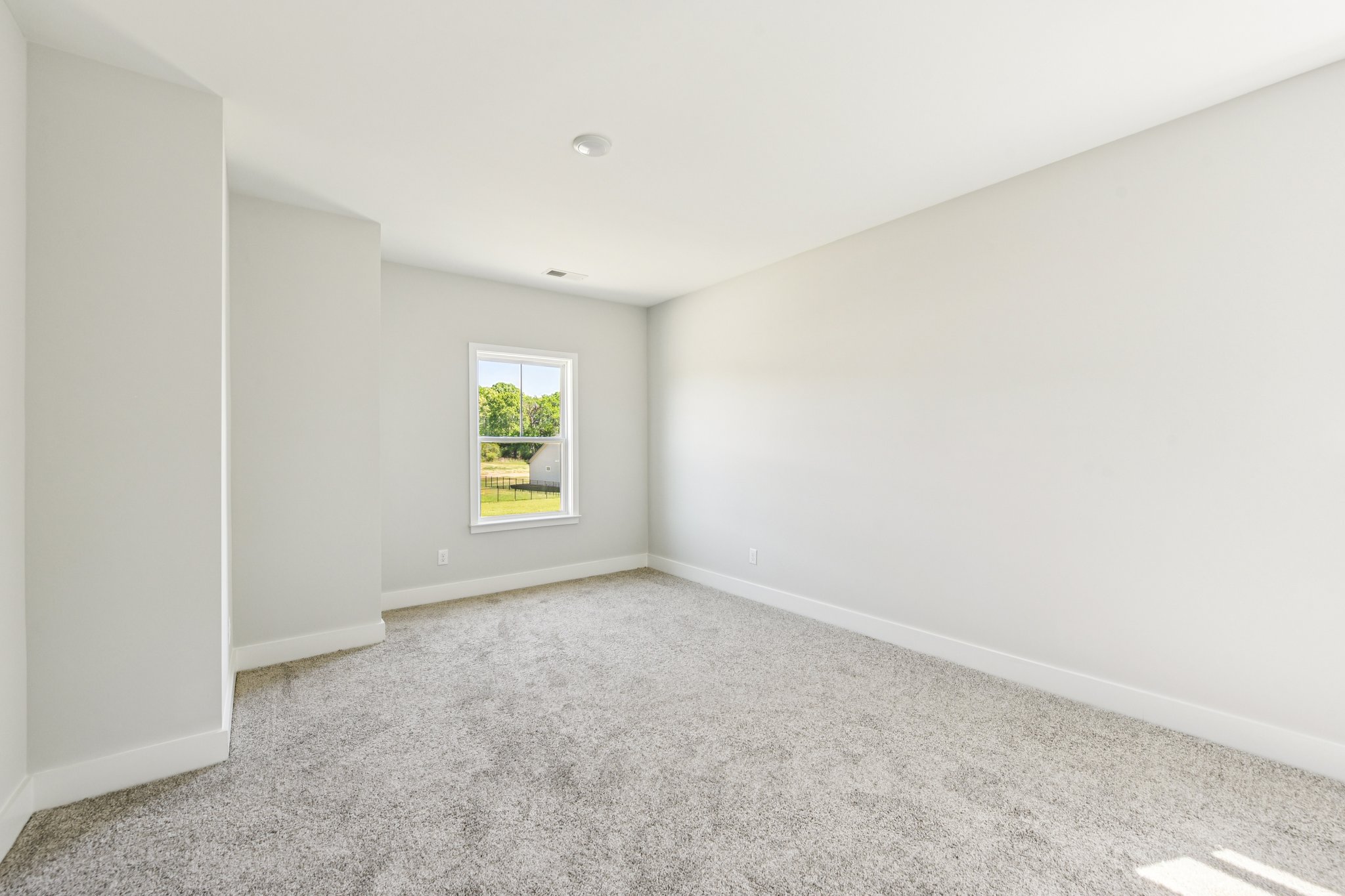 A room with a window and carpet.