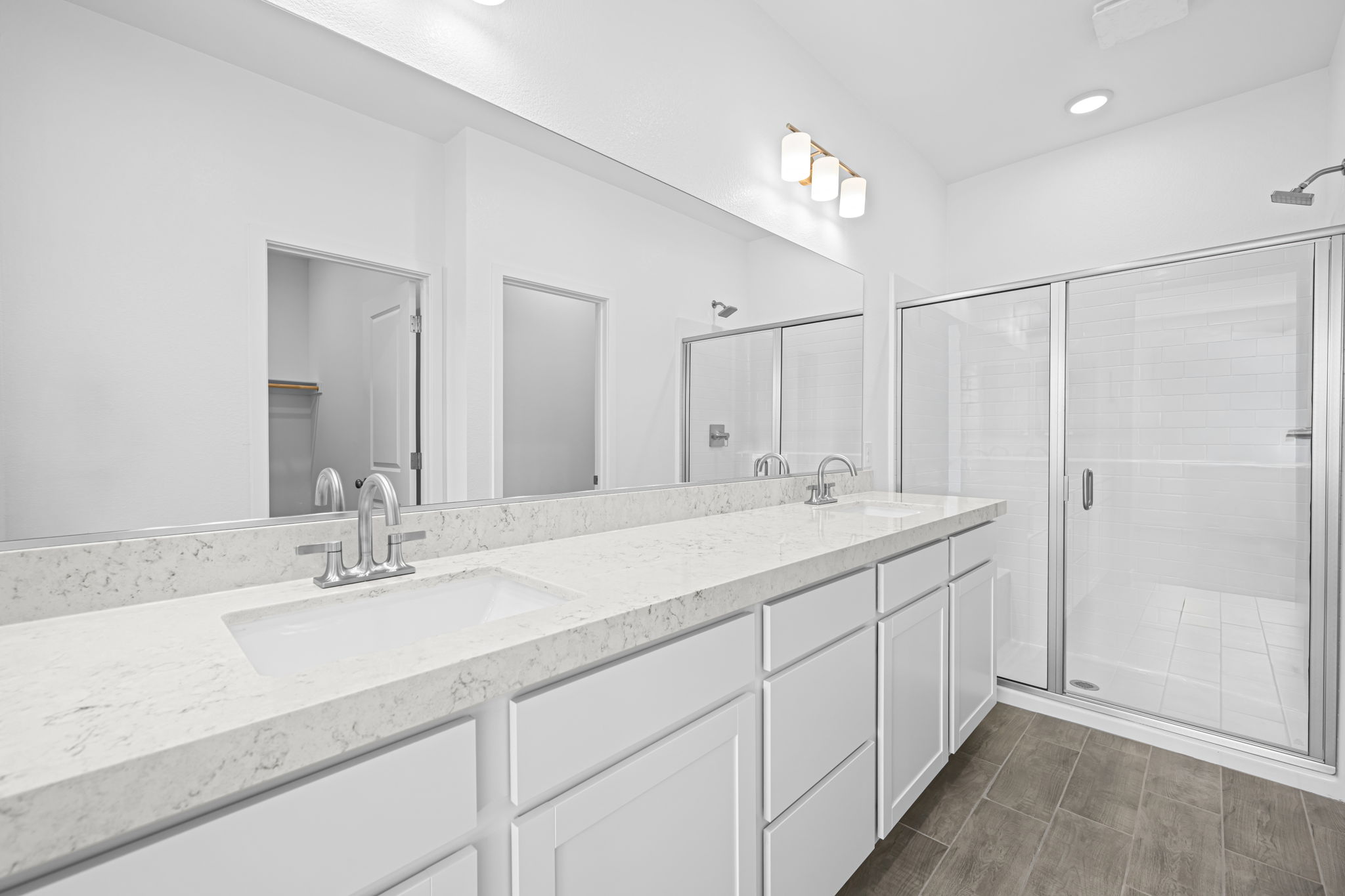 A bathroom with a sink and a shower unit.