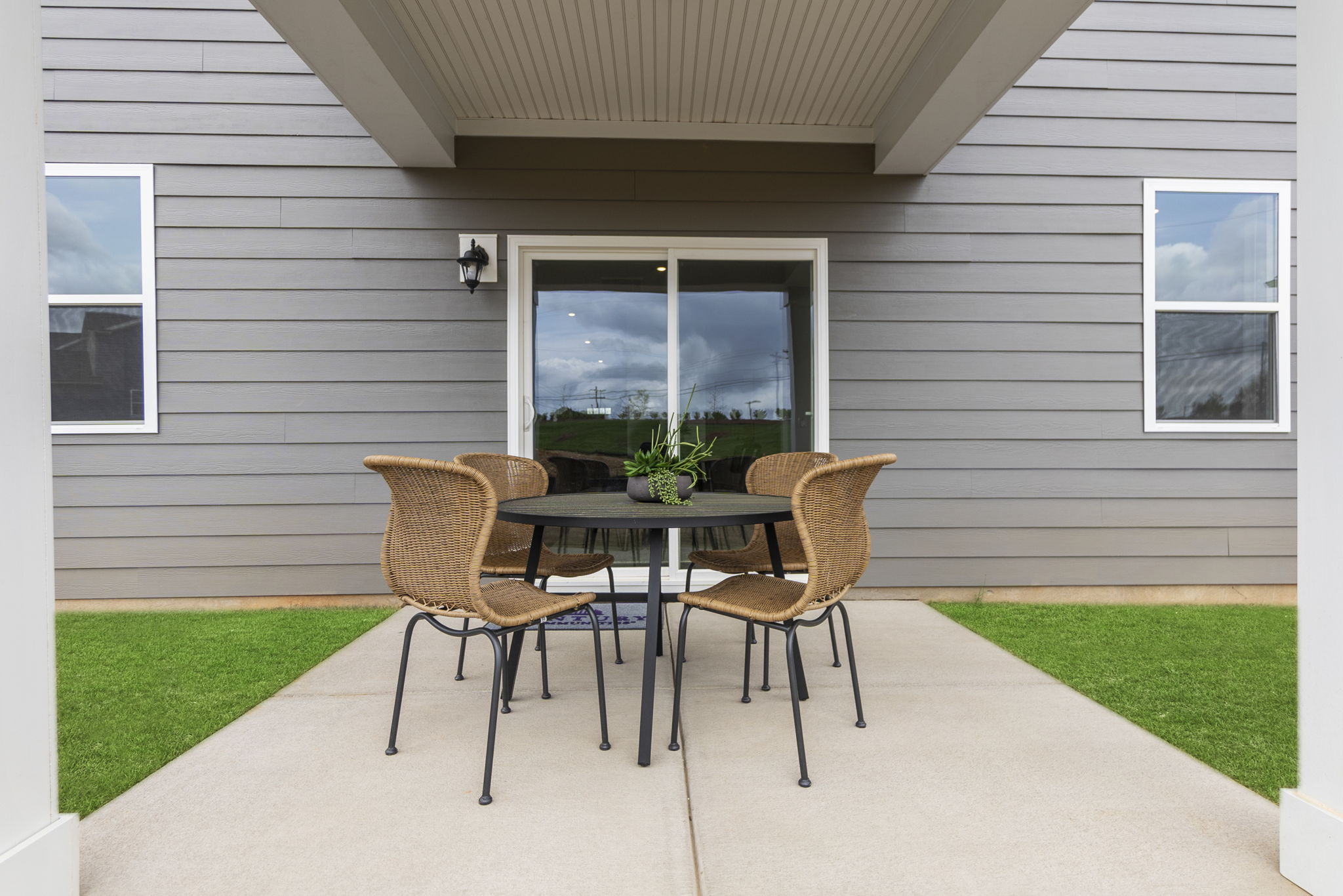 A table and chairs outside a house.