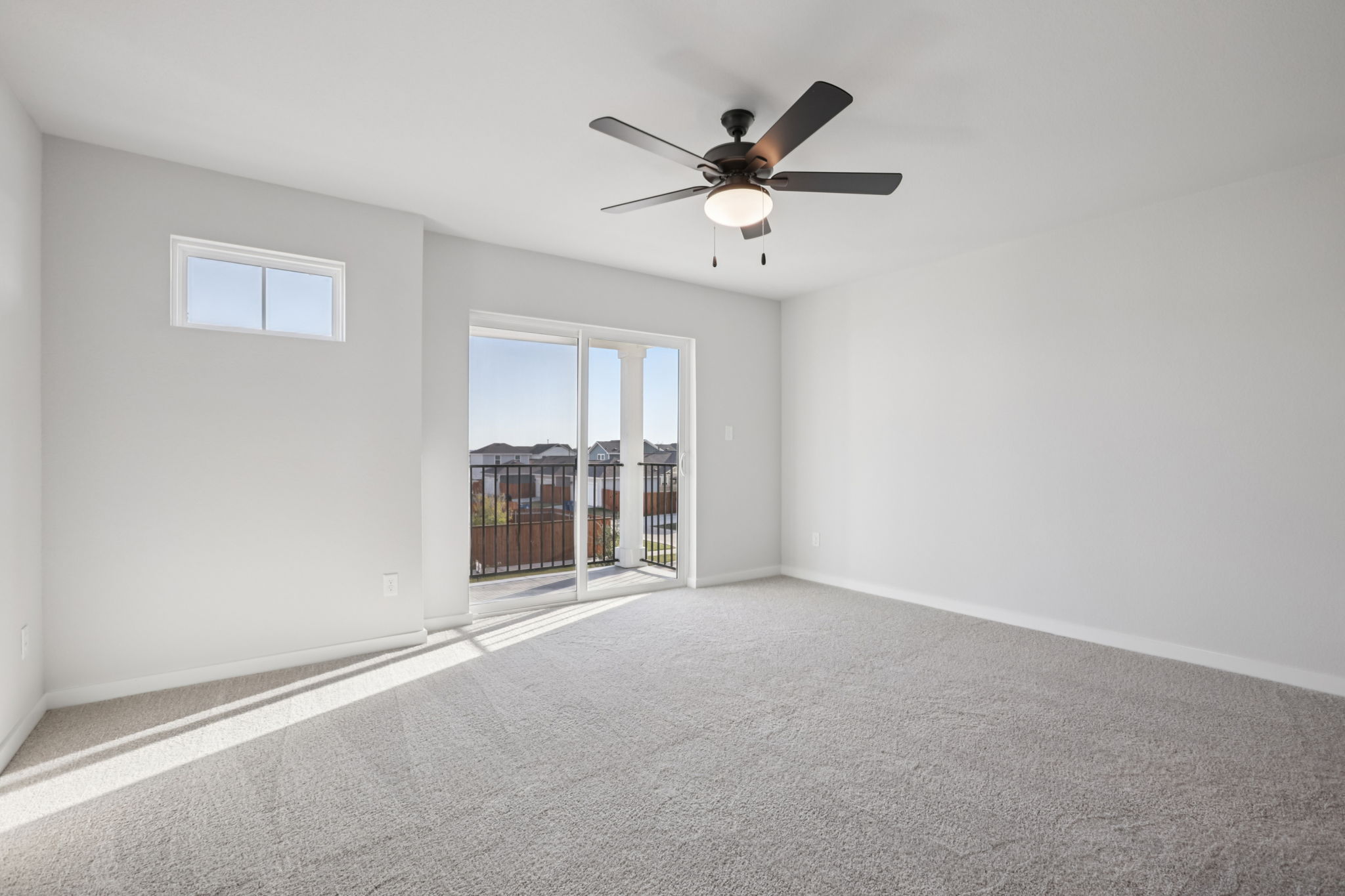 A room with a ceiling fan and a window.