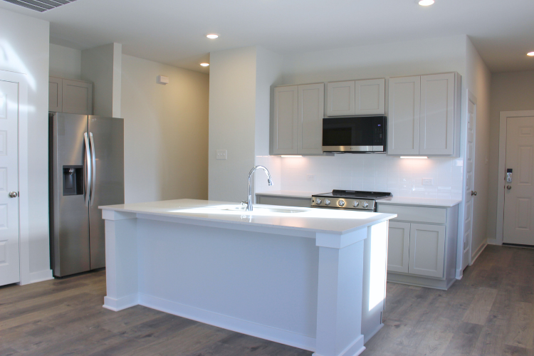 A kitchen with white cabinets.