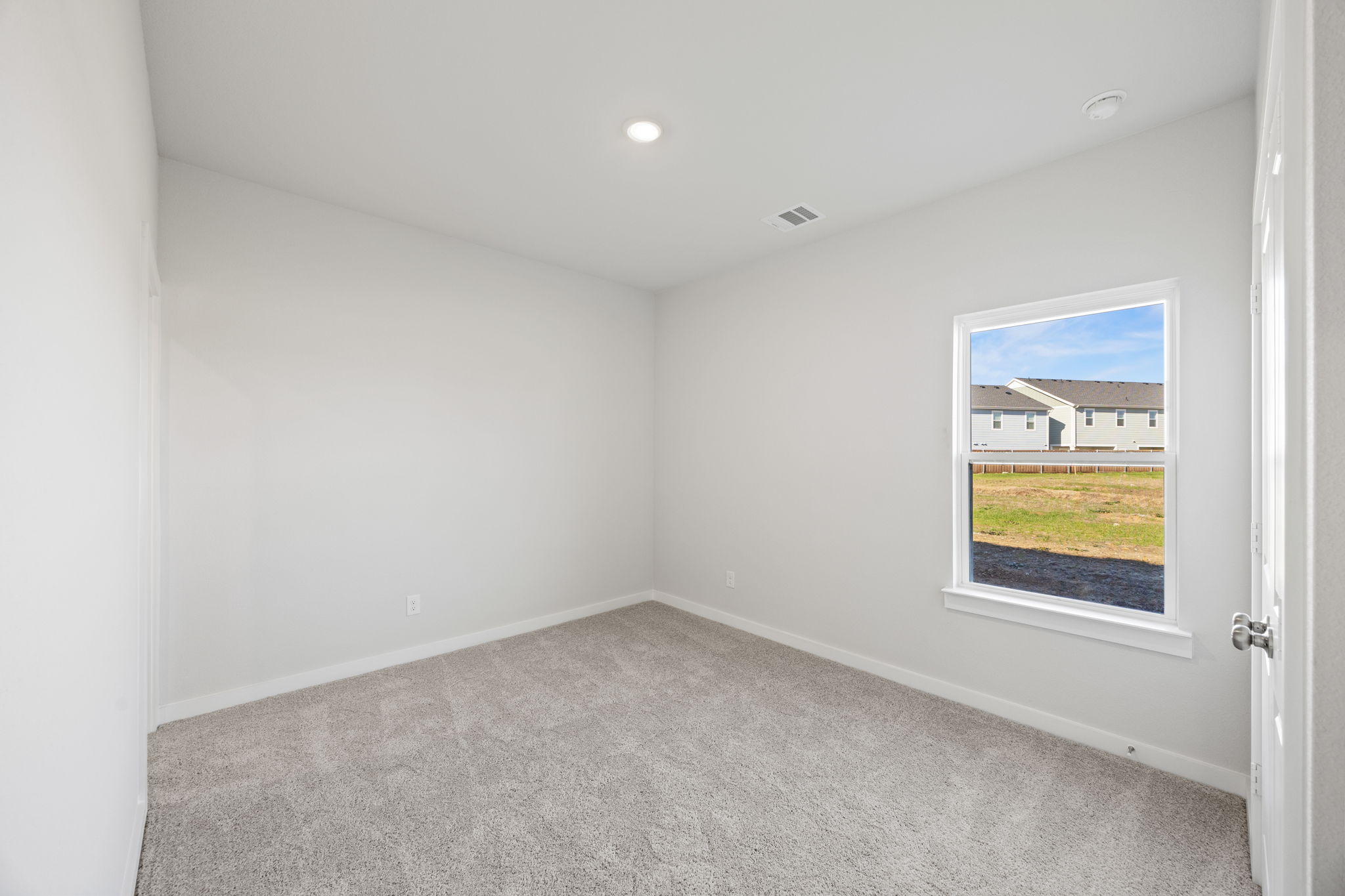 A room with a window and a carpet.