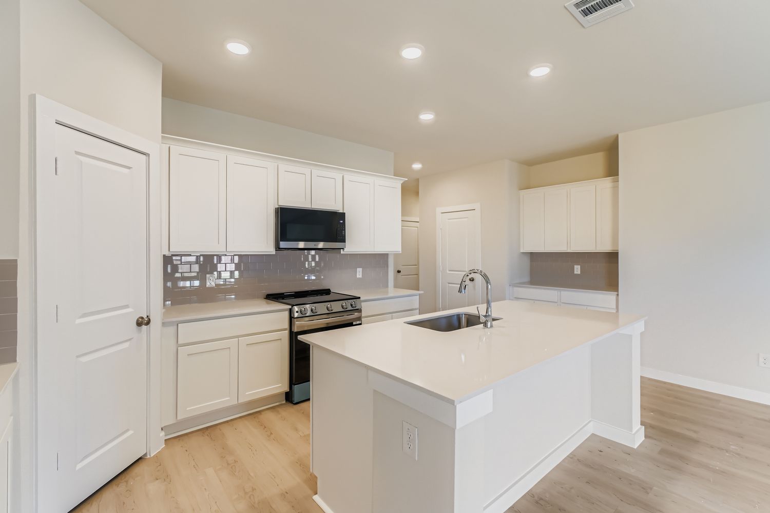 A kitchen with white cabinets.