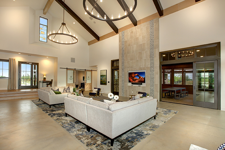 A large living room with a large white couch and a large television.