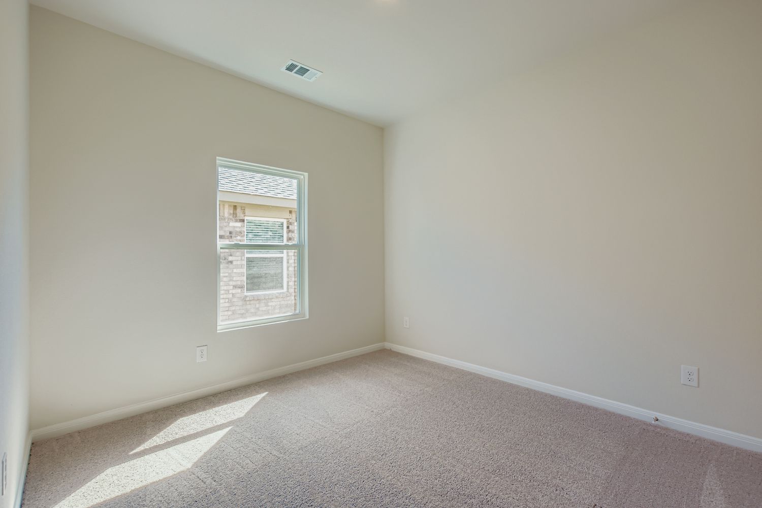 A room with a carpet and a window.