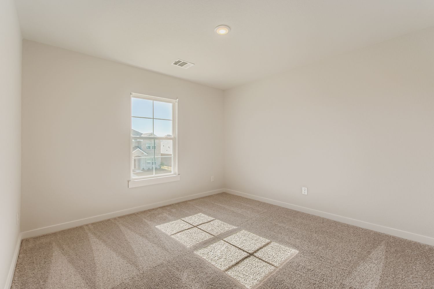 A room with a window and carpet.