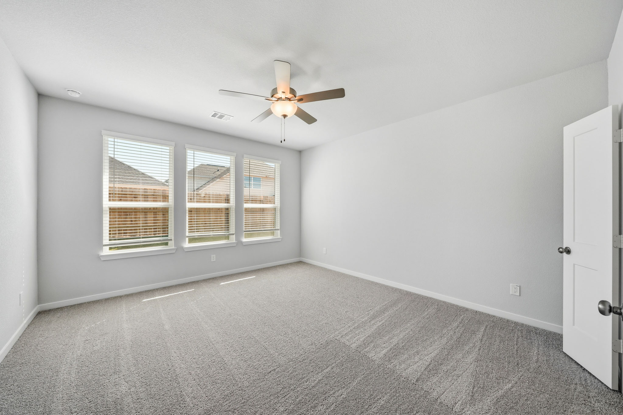 A room with a ceiling fan and a window.