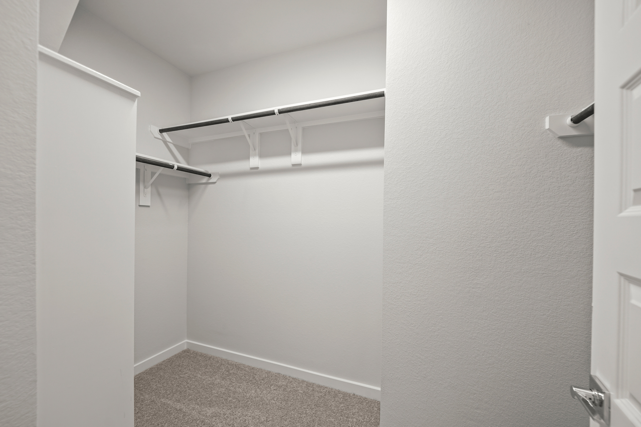 A white hallway with a metal railing.