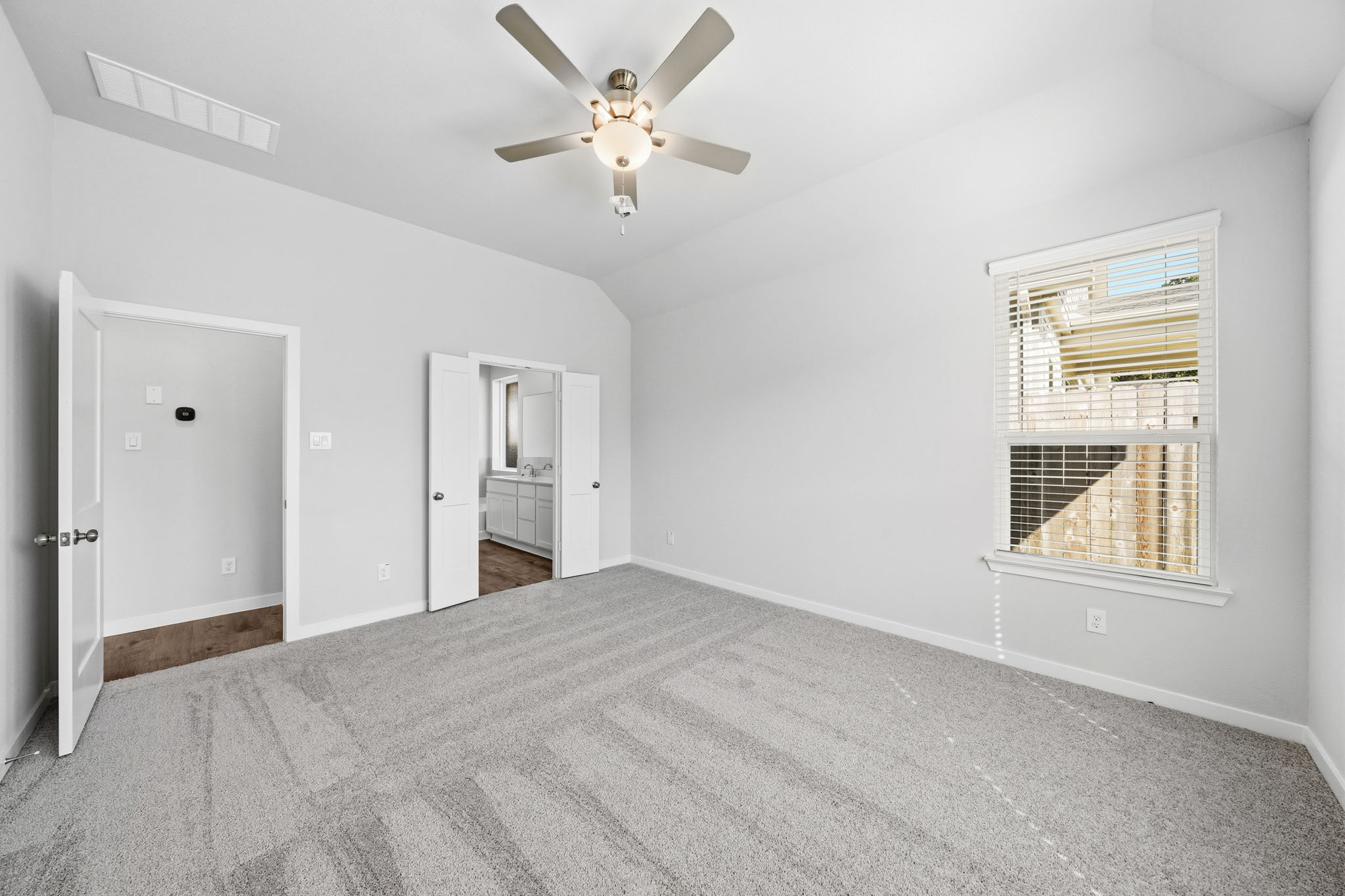 A room with a ceiling fan and a window.