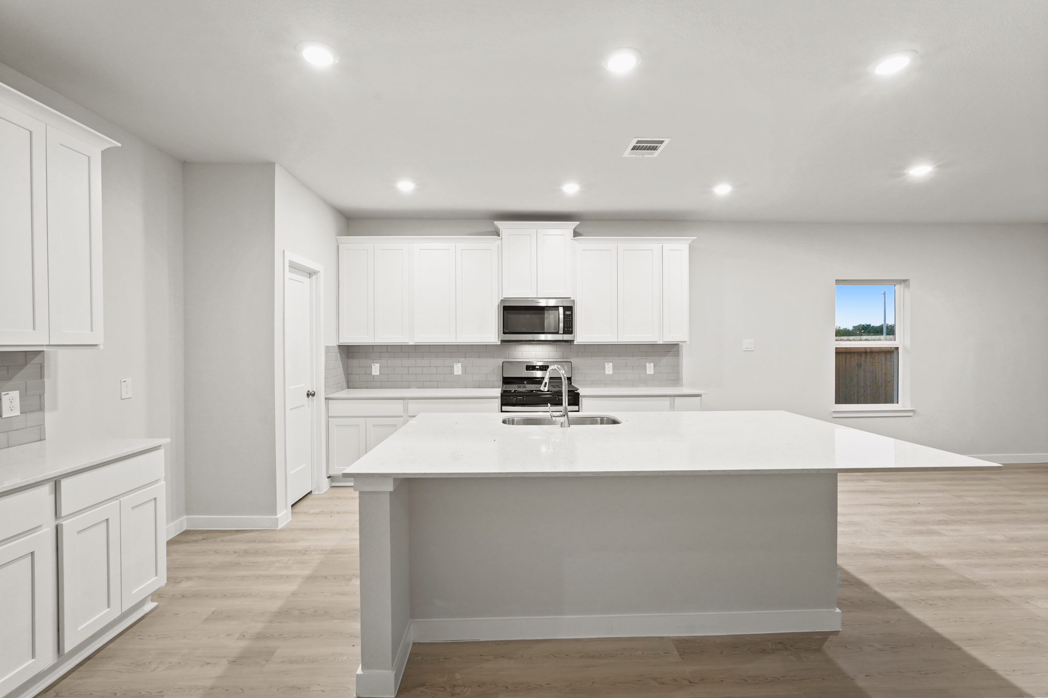 A kitchen with white cabinets.