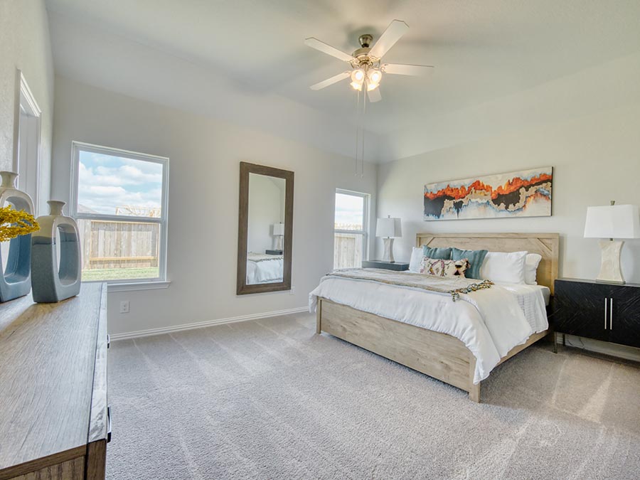 A bedroom with a bed and a fan.