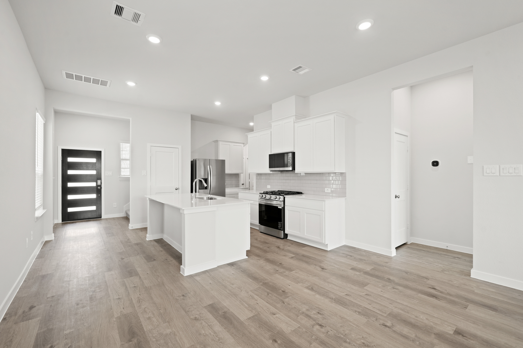 A kitchen with white cabinets.