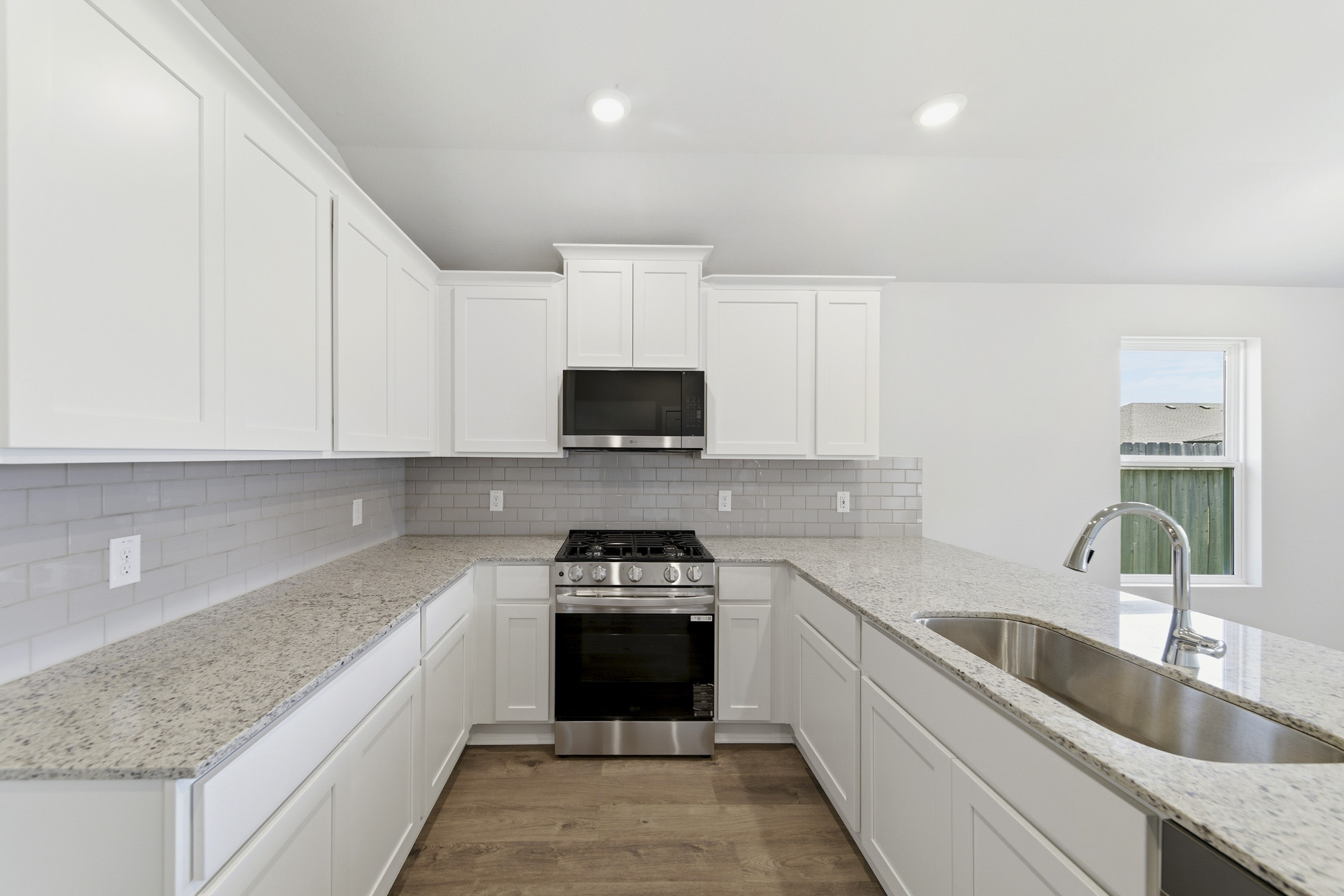 A kitchen with white cabinets.