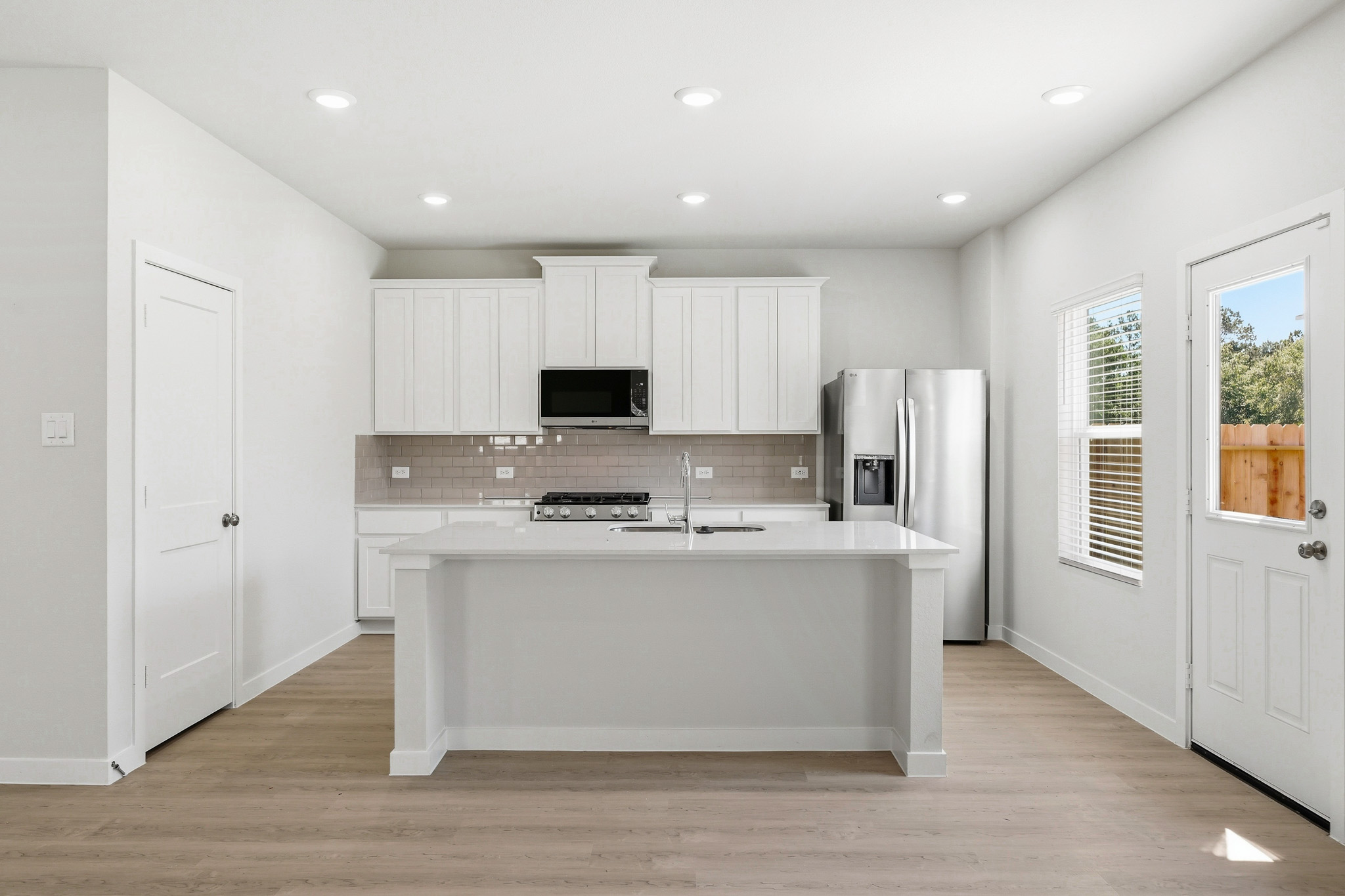 A kitchen with white cabinets.