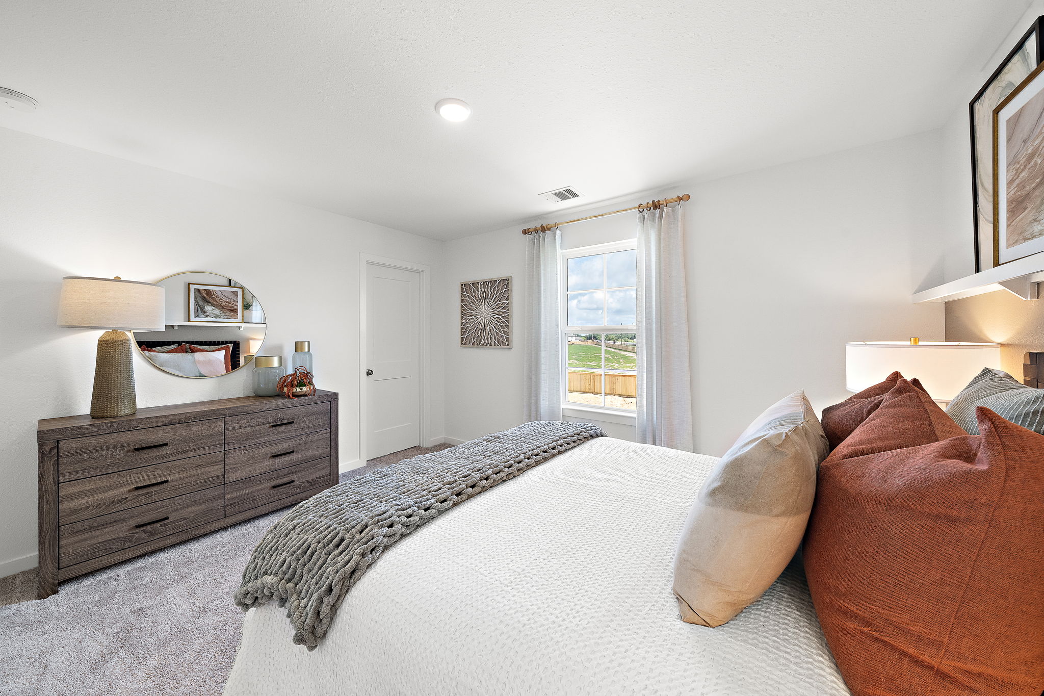 A bedroom with a bed and a dresser.