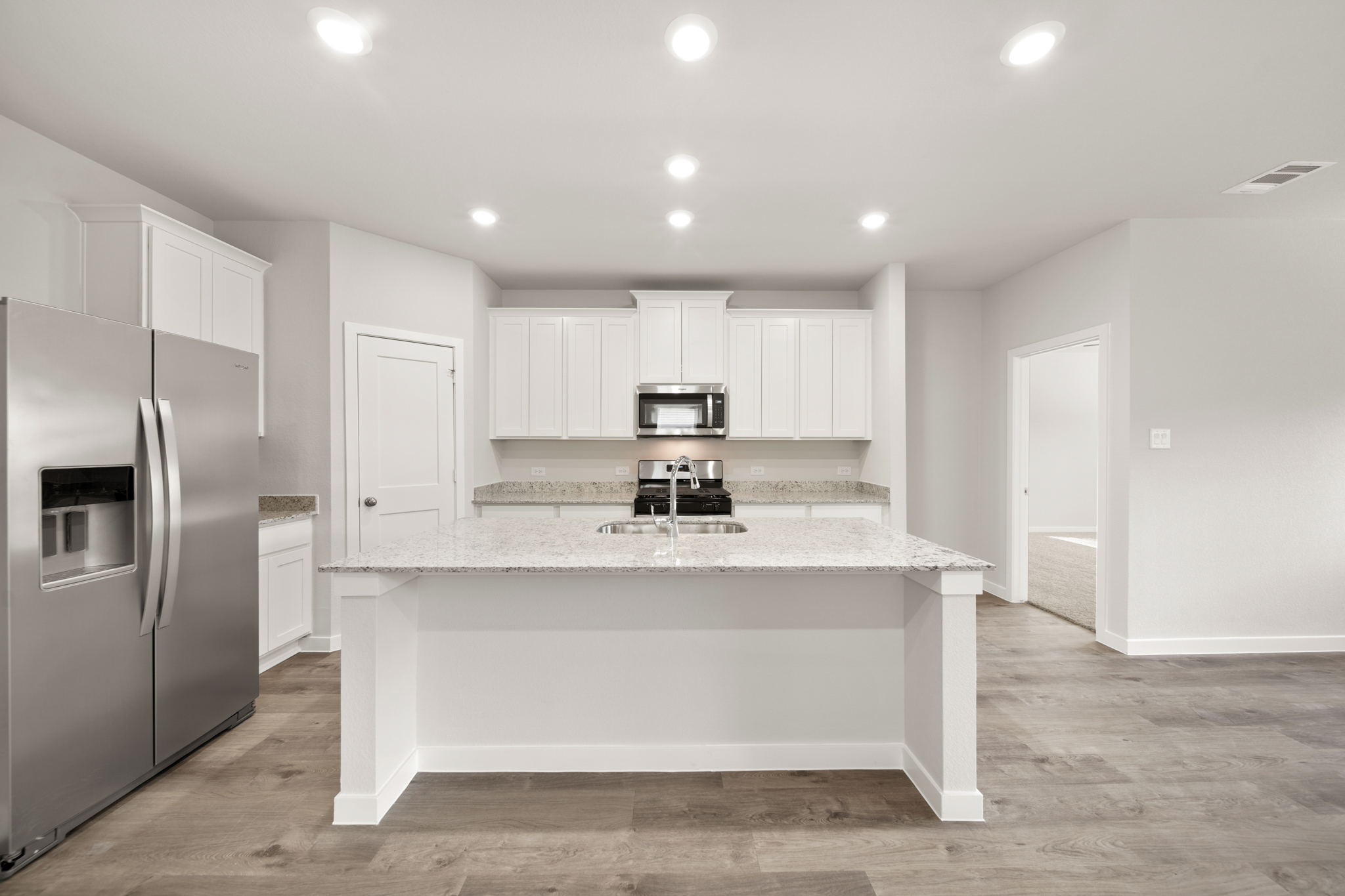 A kitchen with white cabinets.
