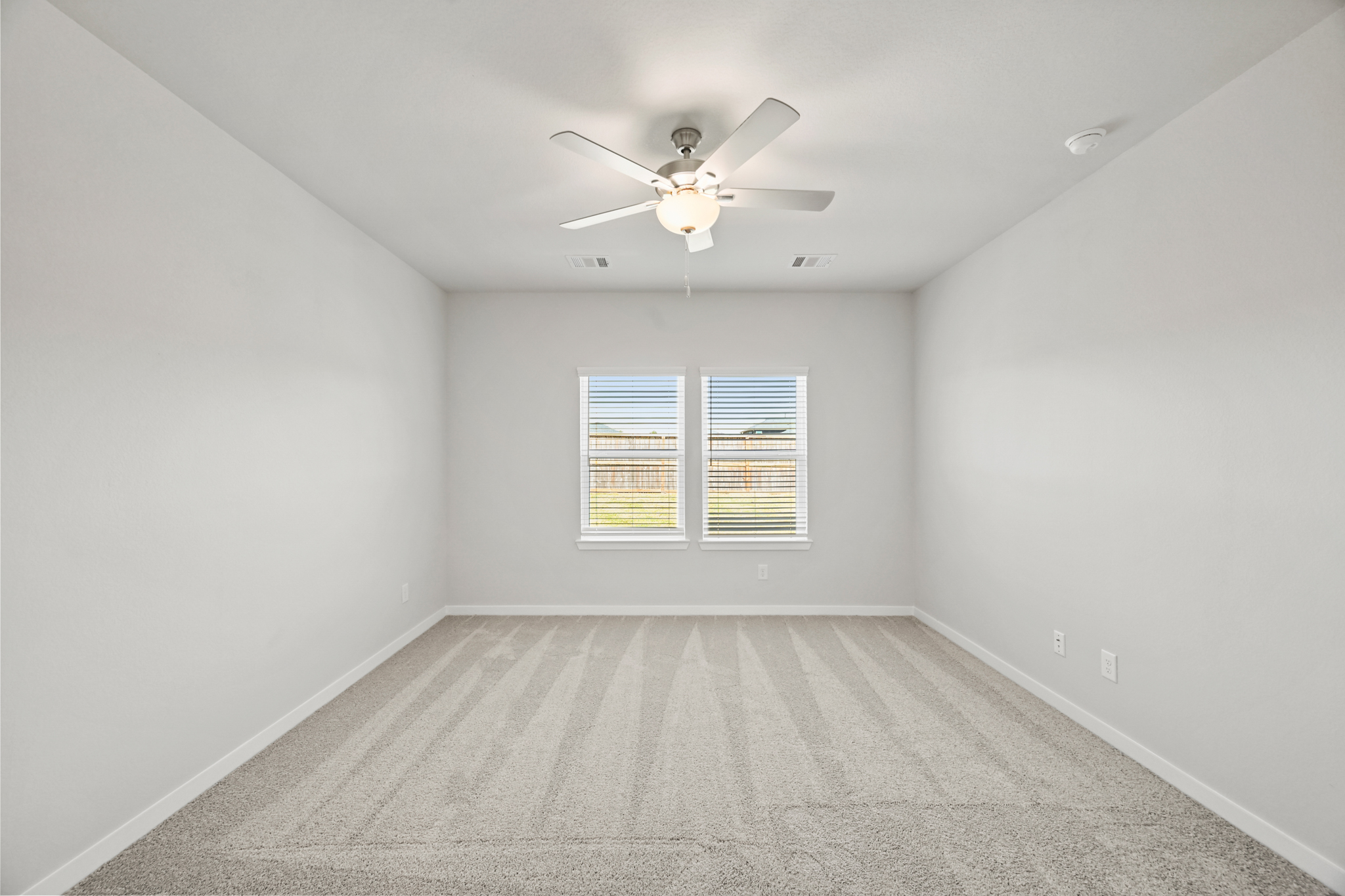 A room with a ceiling fan and a window.