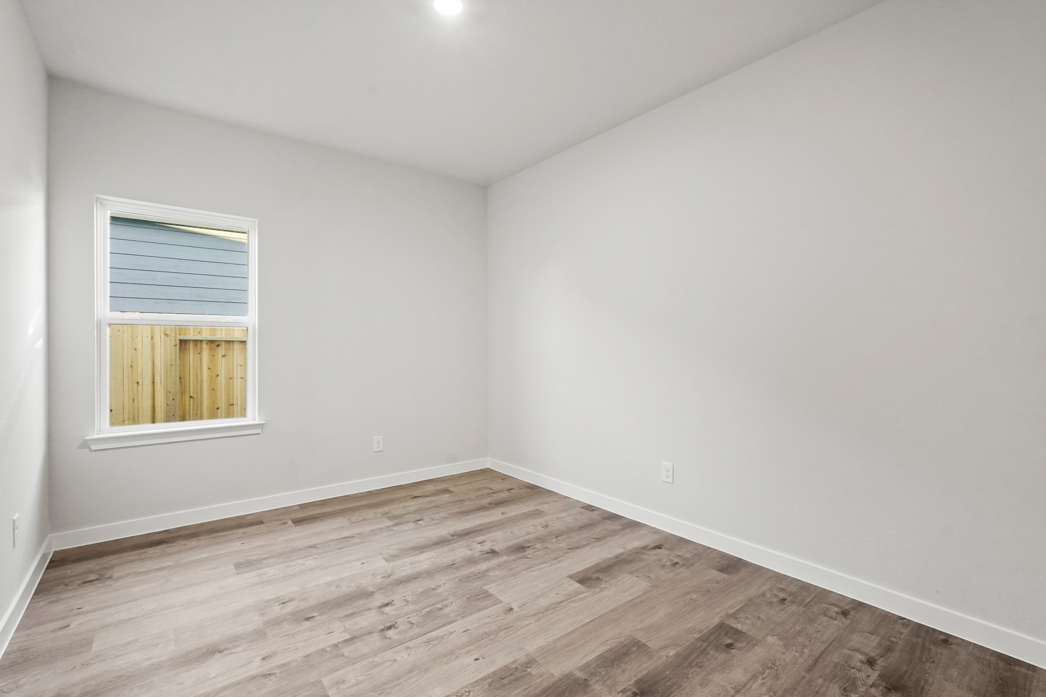 A room with a wood floor and a window.