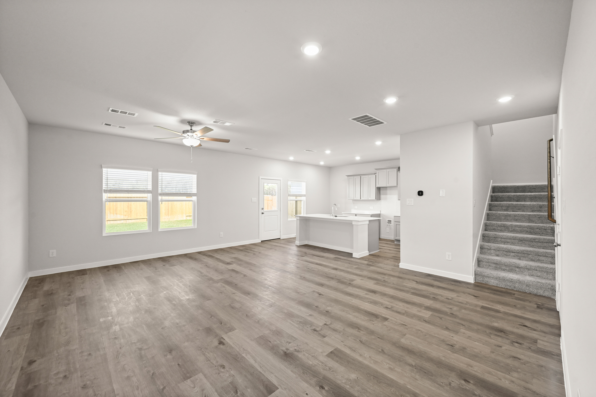 A large empty room with a wood floor and a wood floor.