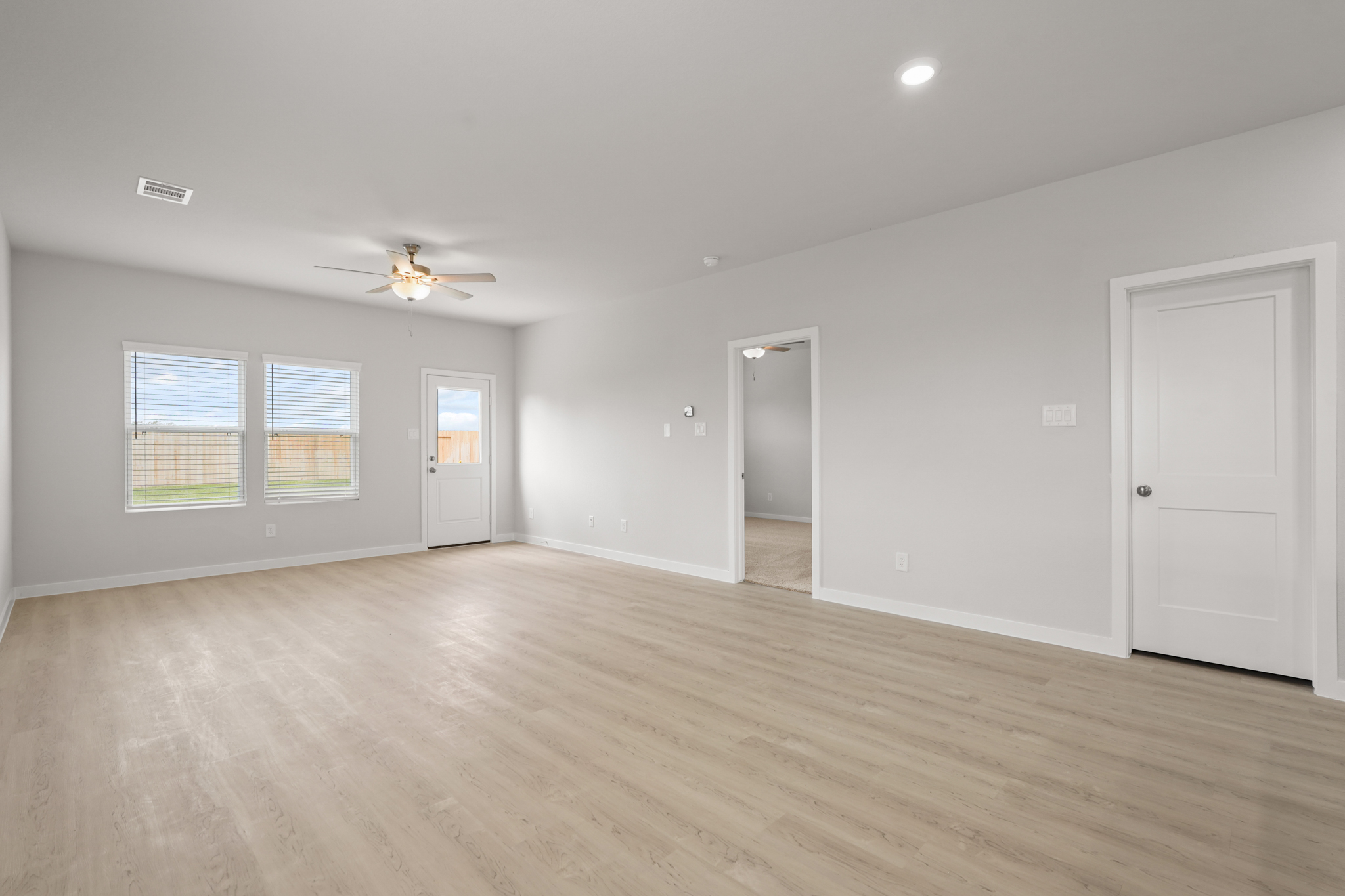 A room with a wood floor and a ceiling fan.