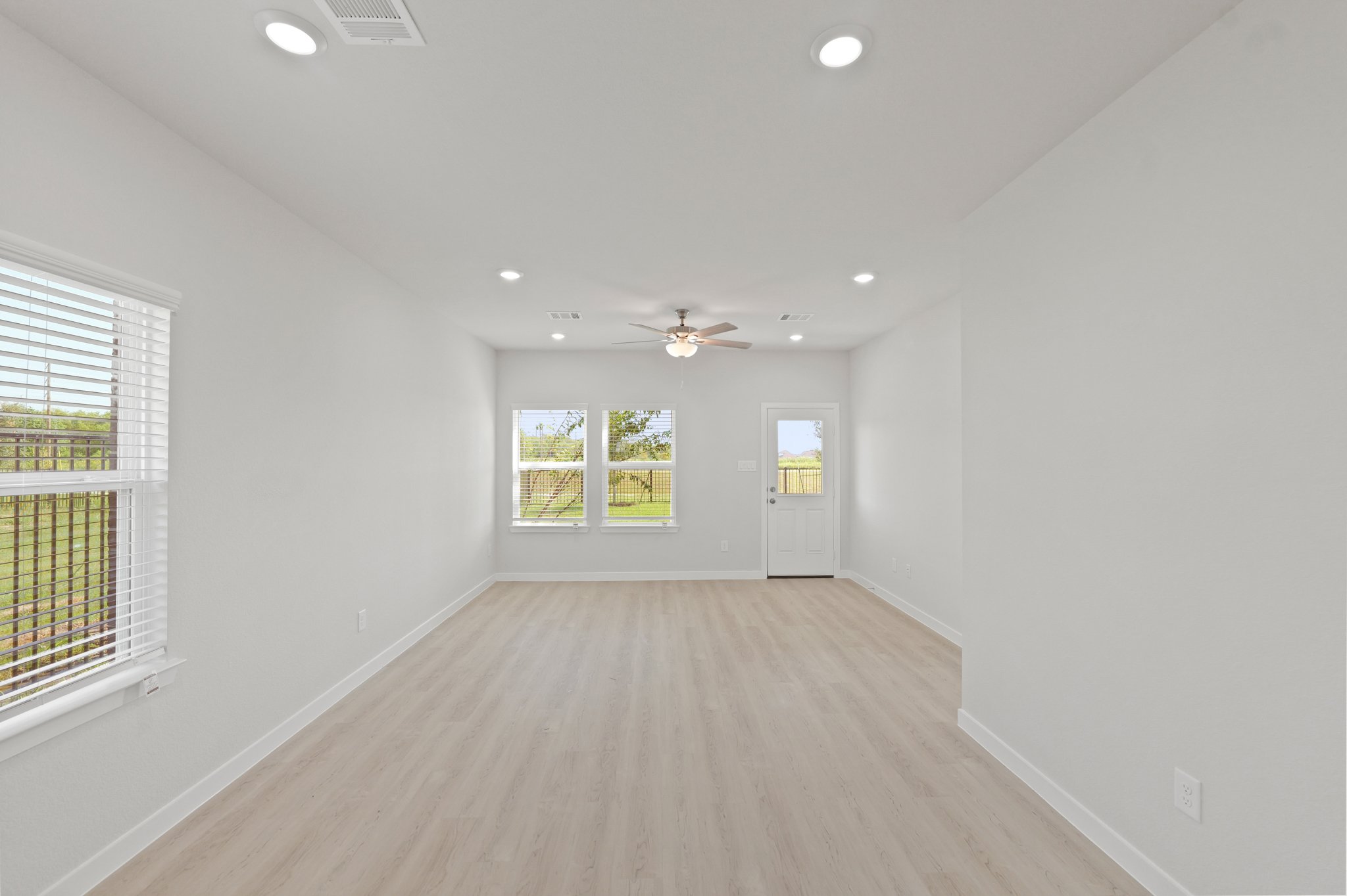 A room with a wood floor and windows.