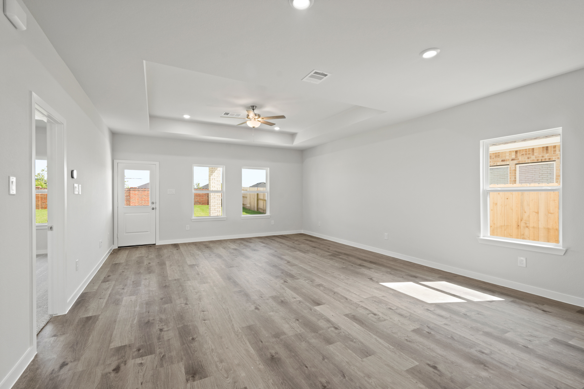 A room with a wood floor and a ceiling fan.