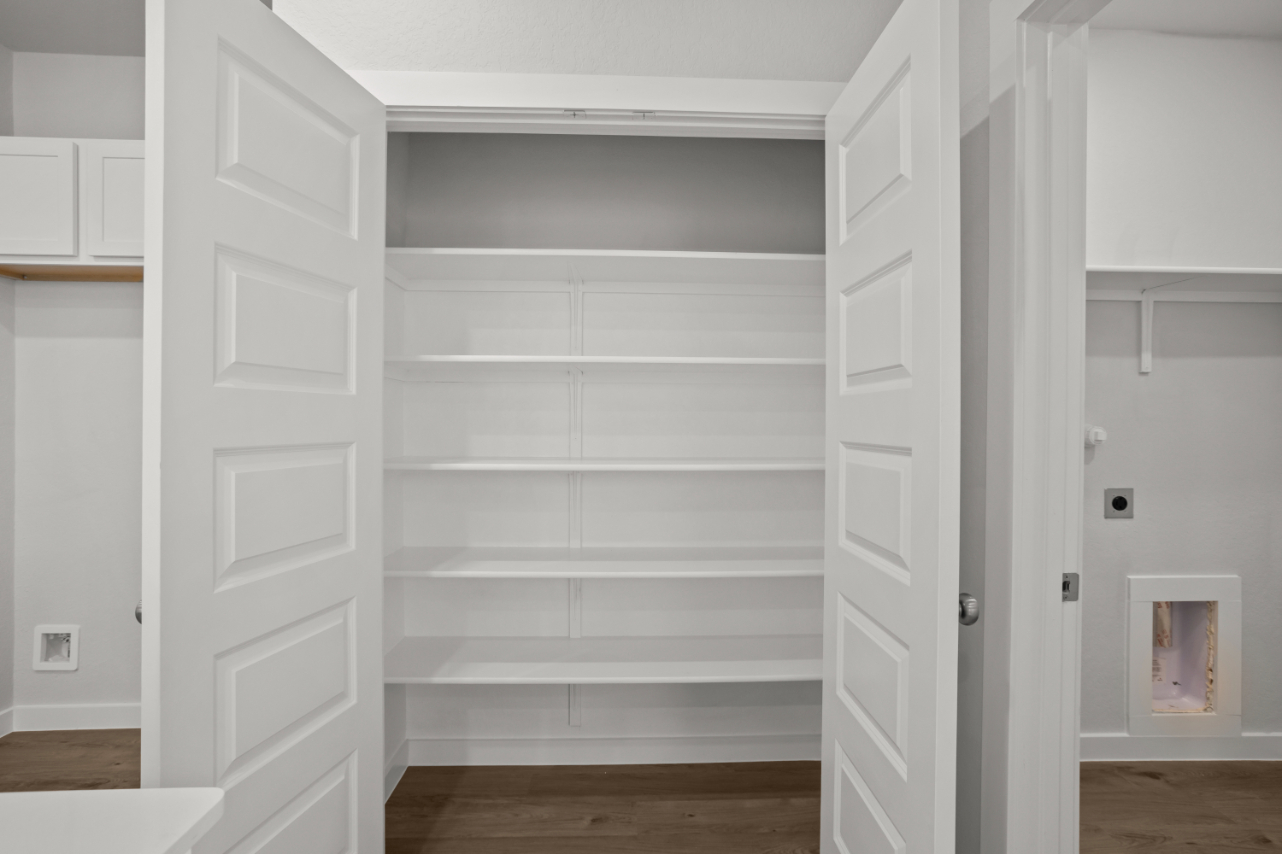 A white closet with white doors.