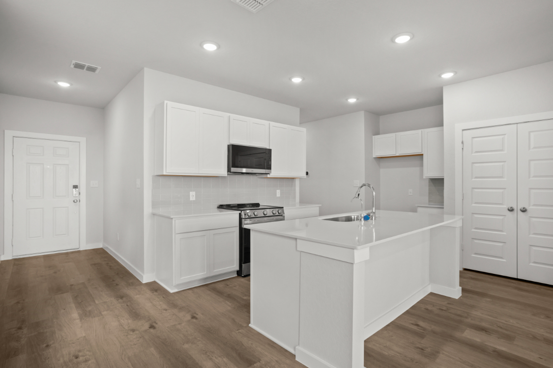 A kitchen with white cabinets.