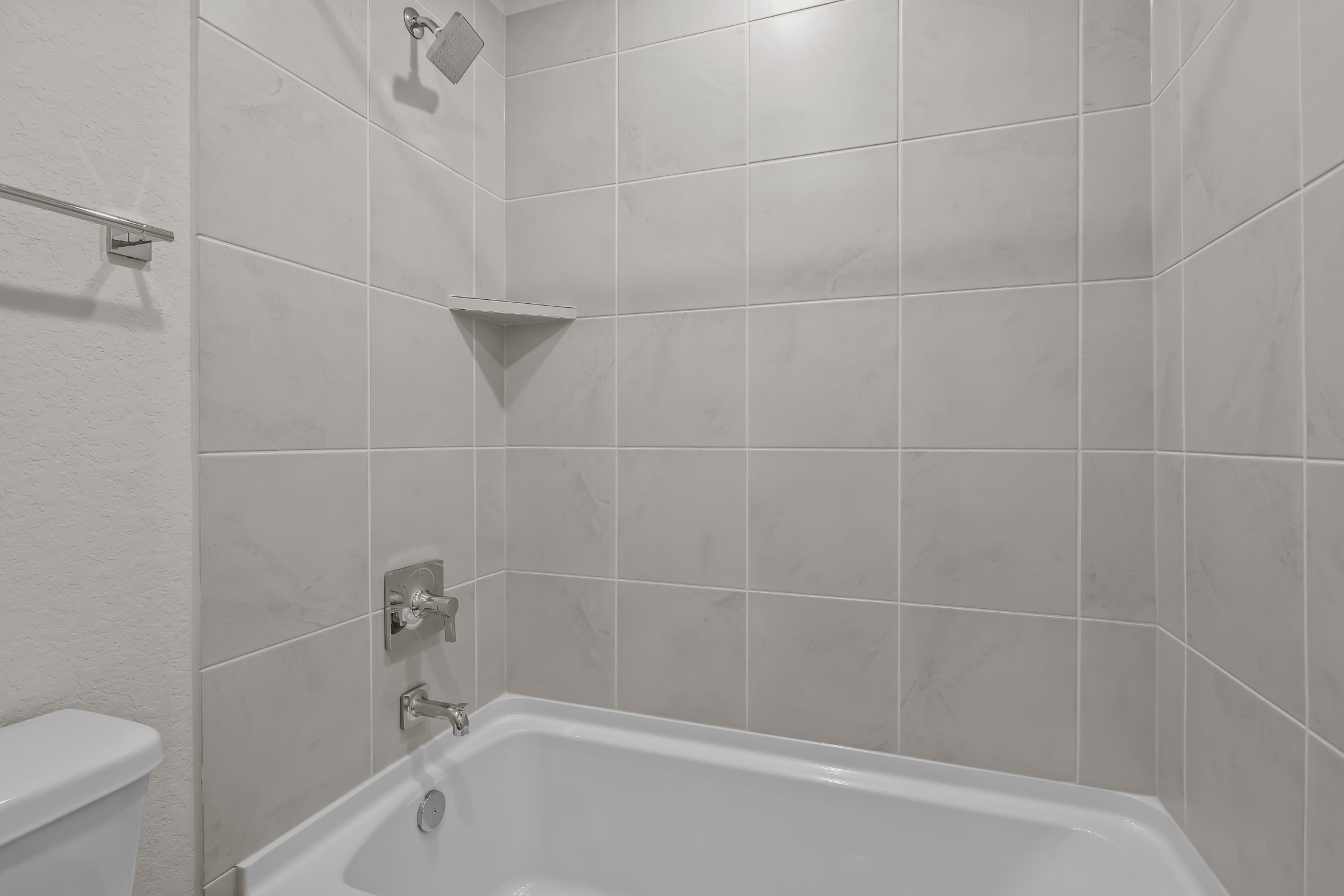 A white bathroom with a bathtub.